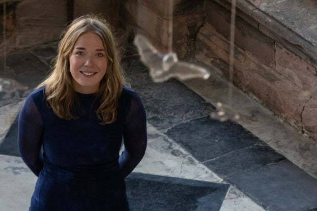 Artist Rachel Blackwell stands beneath her winning artwork, Flight of the Pipistrelles, tiny pewter bats suspended from the ceiling in Seaton Delaval Hall's Entrance Hall