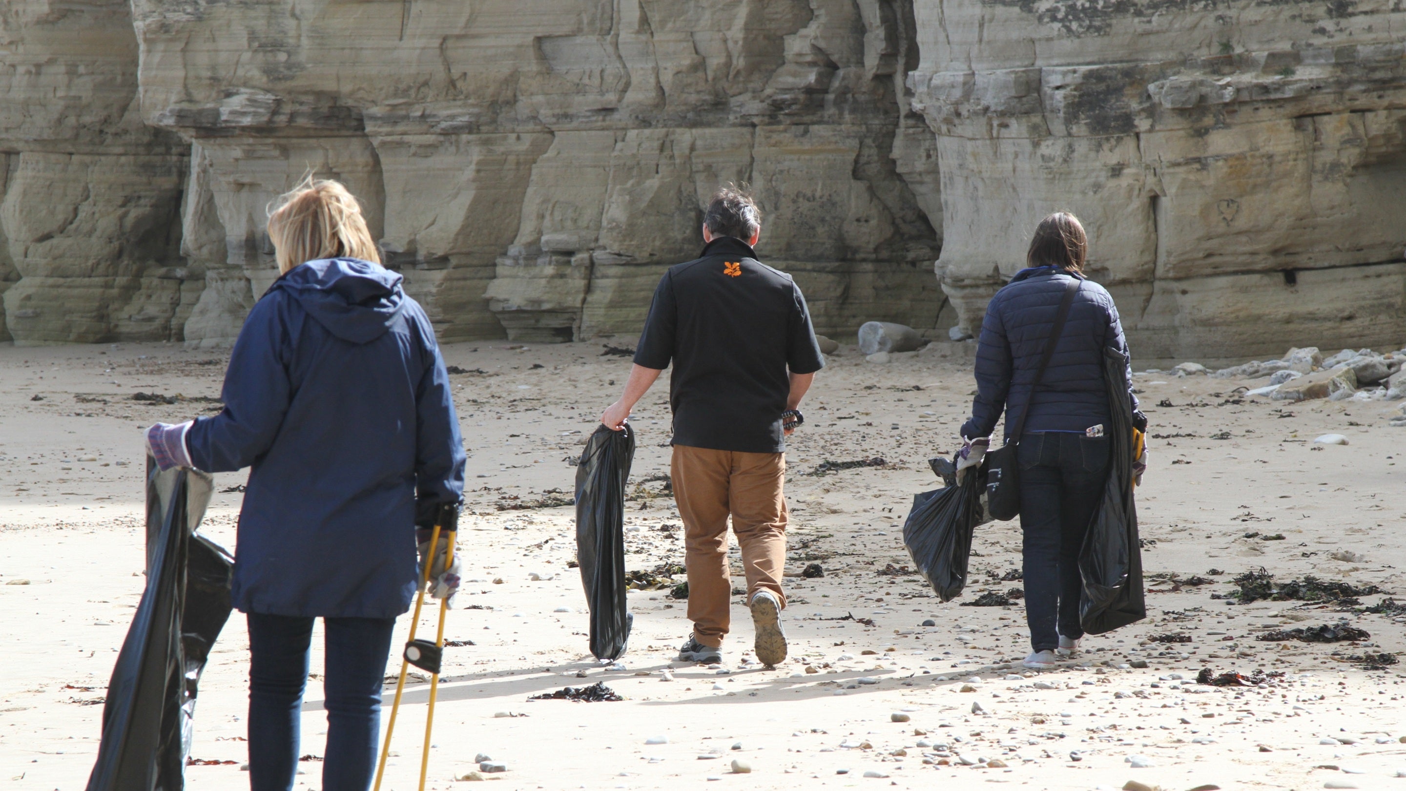 Volunteers and staff members cleaning the beach at Marsden Bay near Souter Lighthouse, Tyne & Wear.