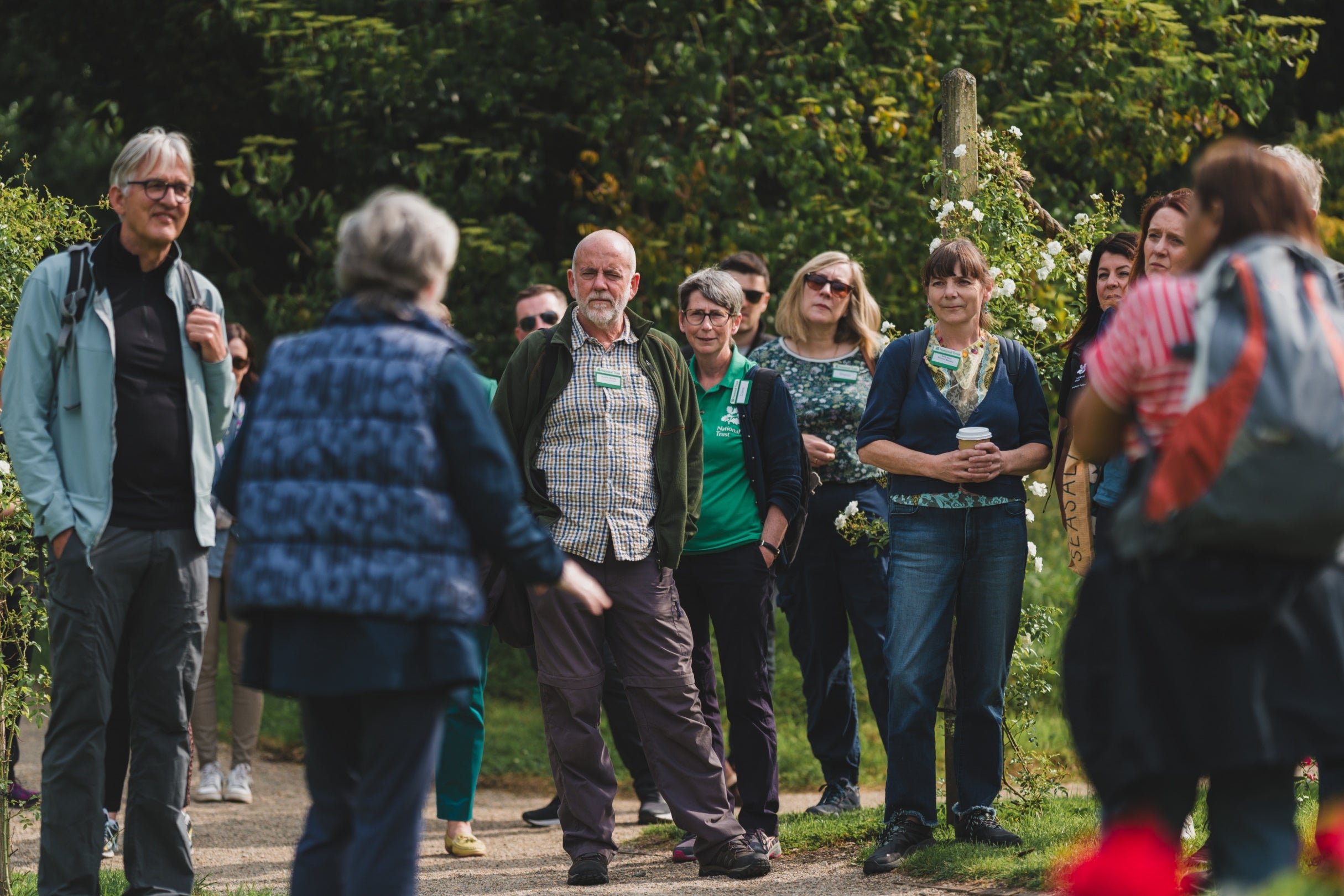A group of people who are National Trust council members gathered together outdoors