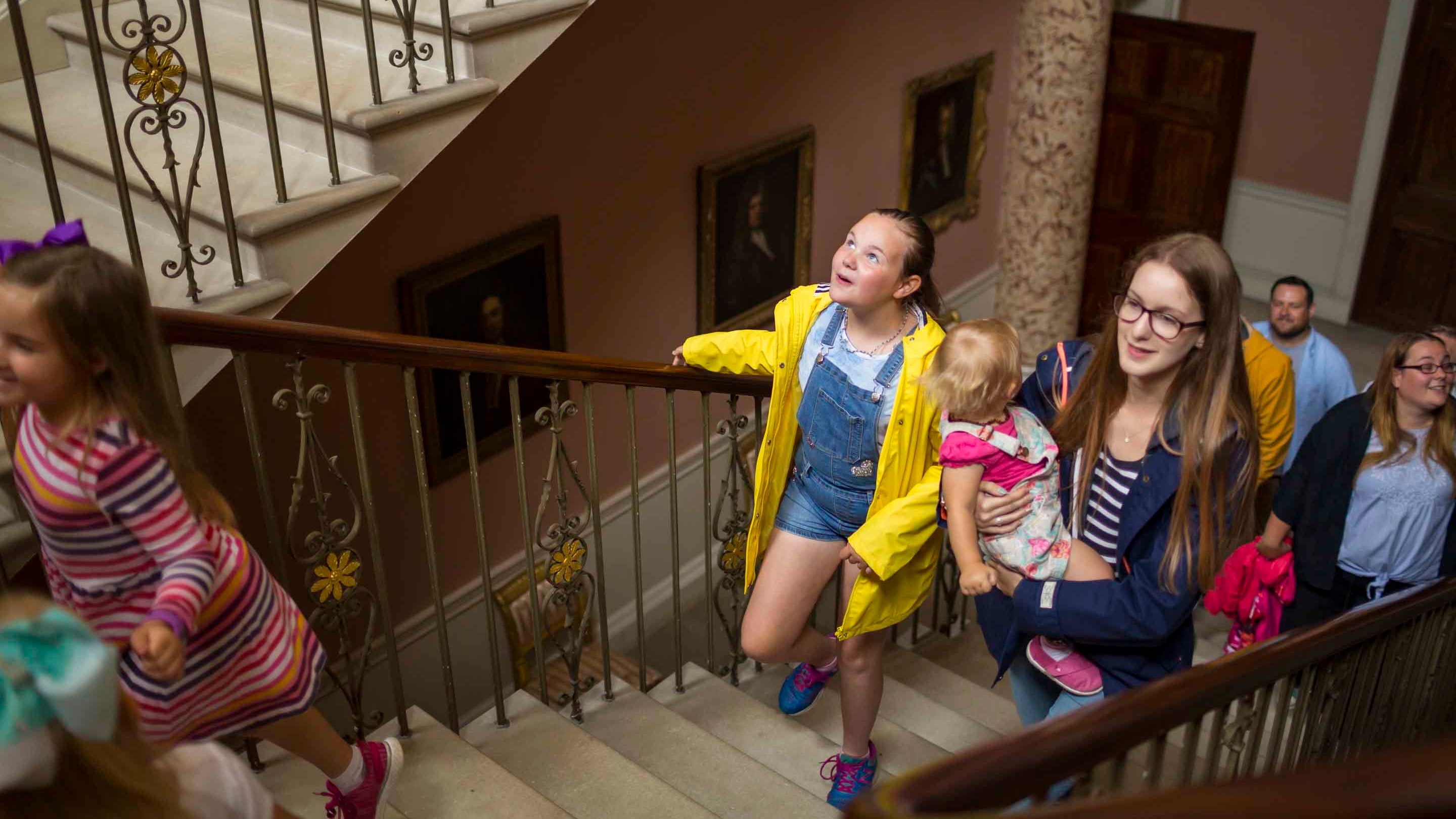 A group of visitors climbing the staircase at Castle Coole