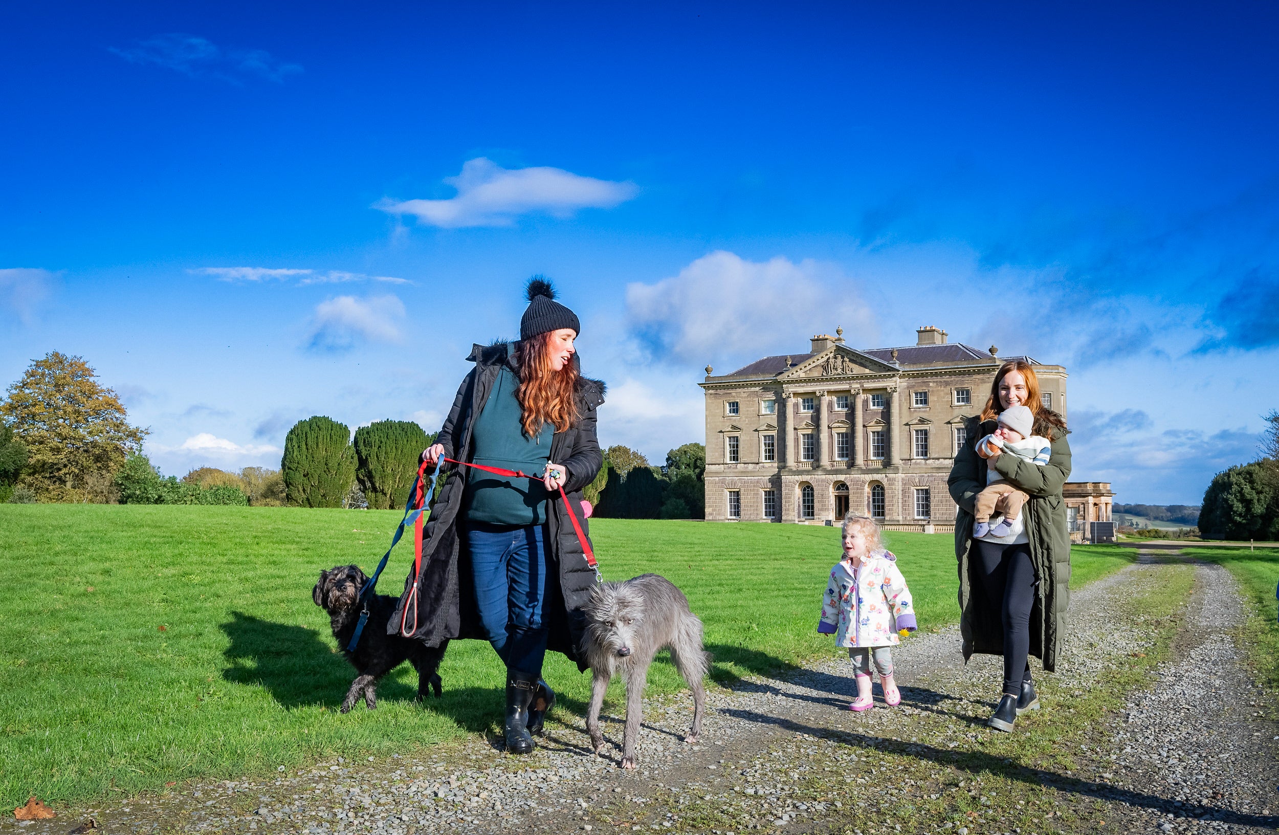 Family enjoying winter walk at the front of the mansion house