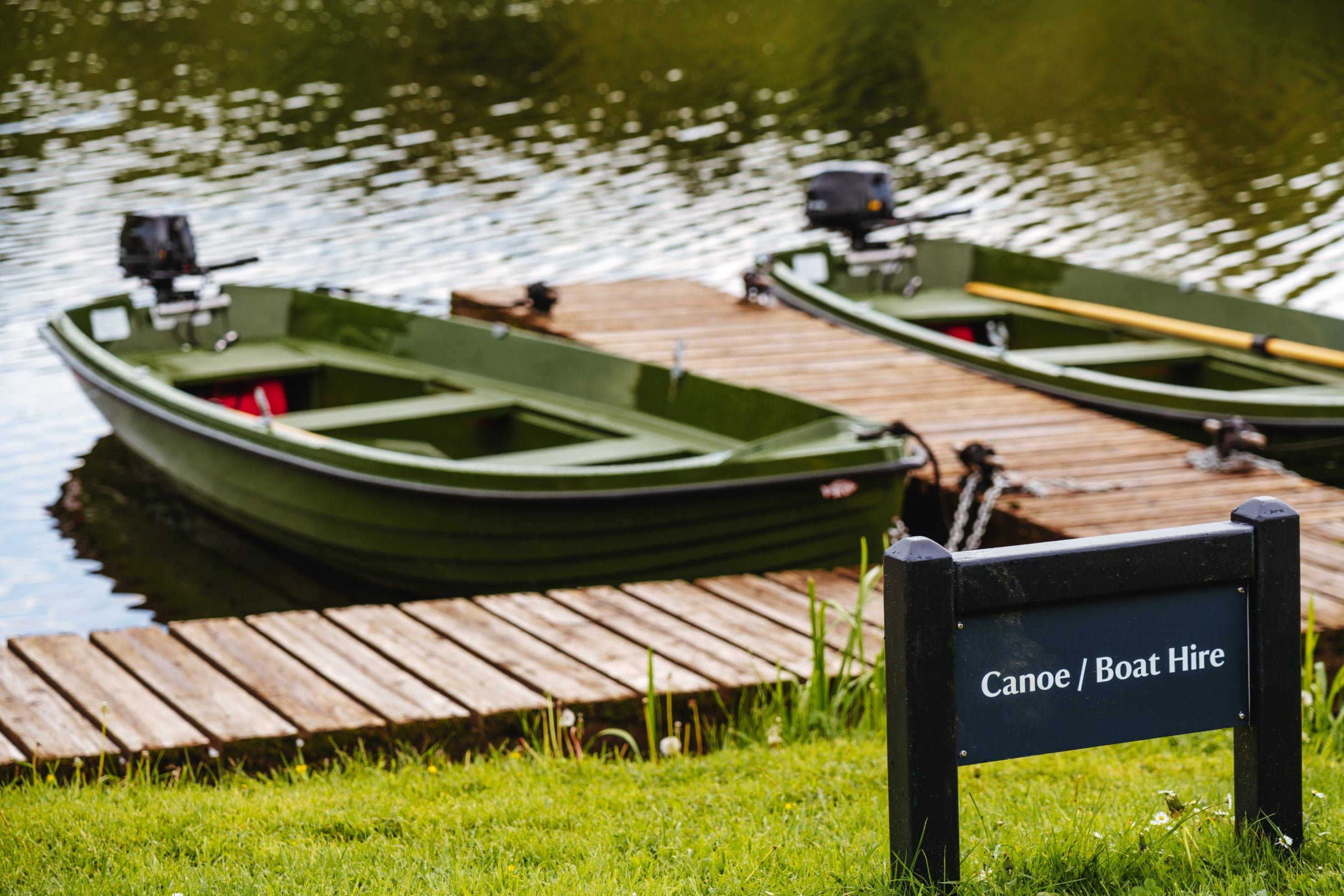 Two row boats sit in the water on a sunny day