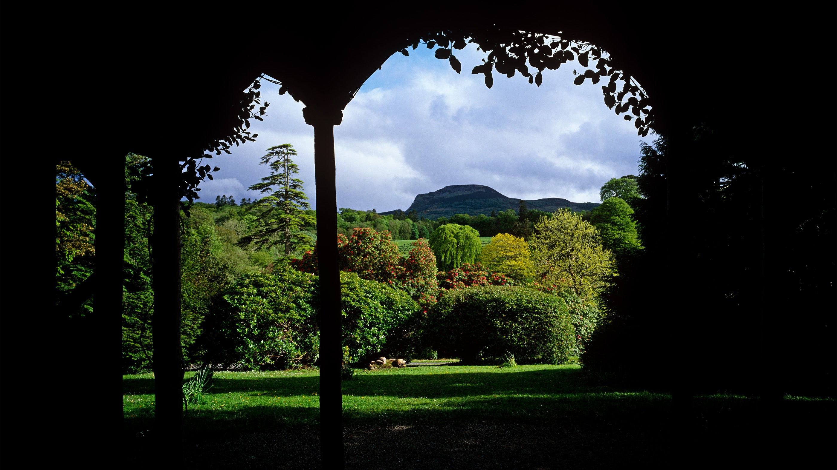 View from Summer House at Florence Court, Co Fermanagh, across the Pleasure Ground planted with ornamental trees and shrubs with a network of paths and in the background Ben Aughlin.