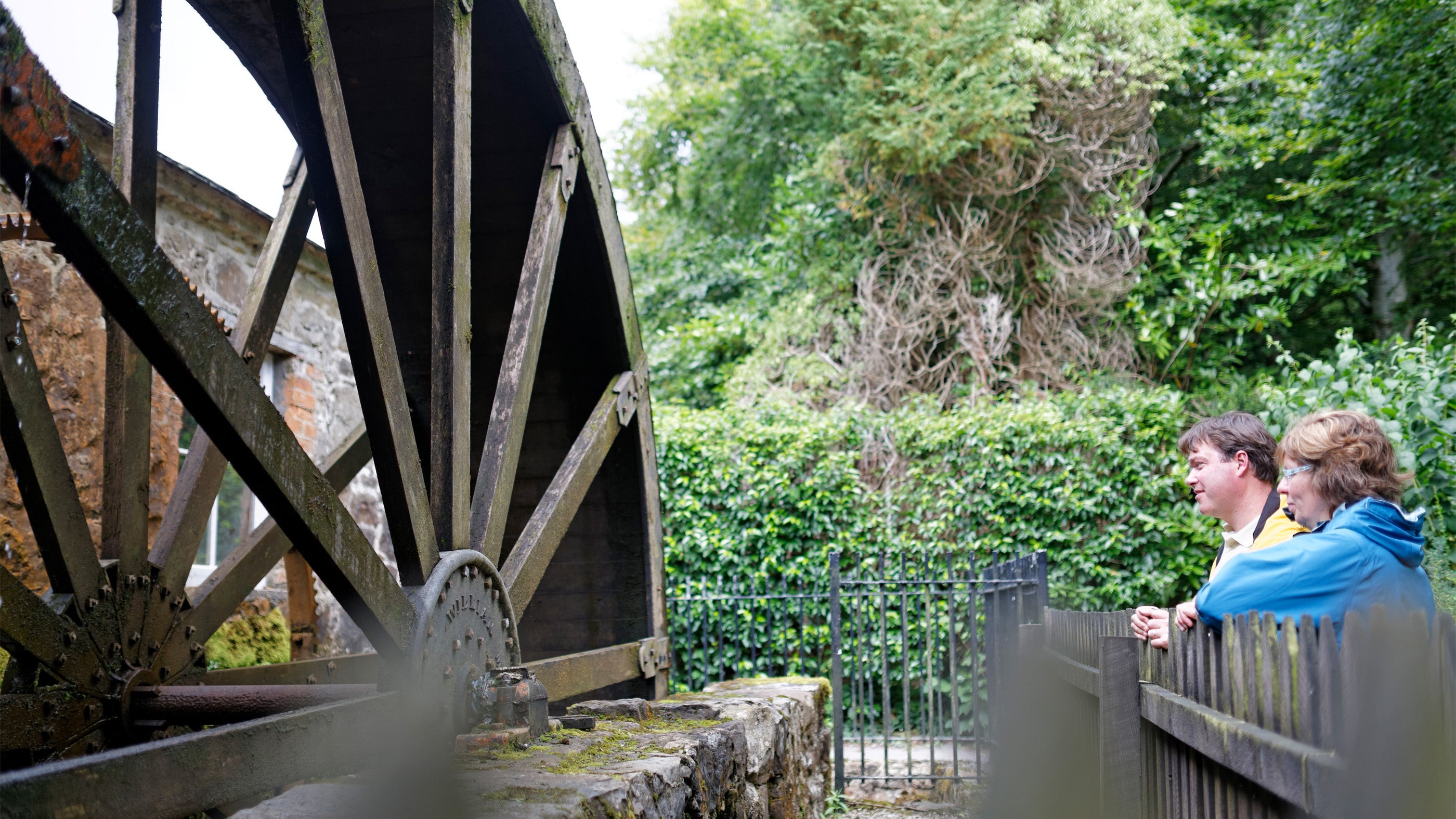 Visitors looking at a water mill, in the grounds of Florence Court, County Fermanagh