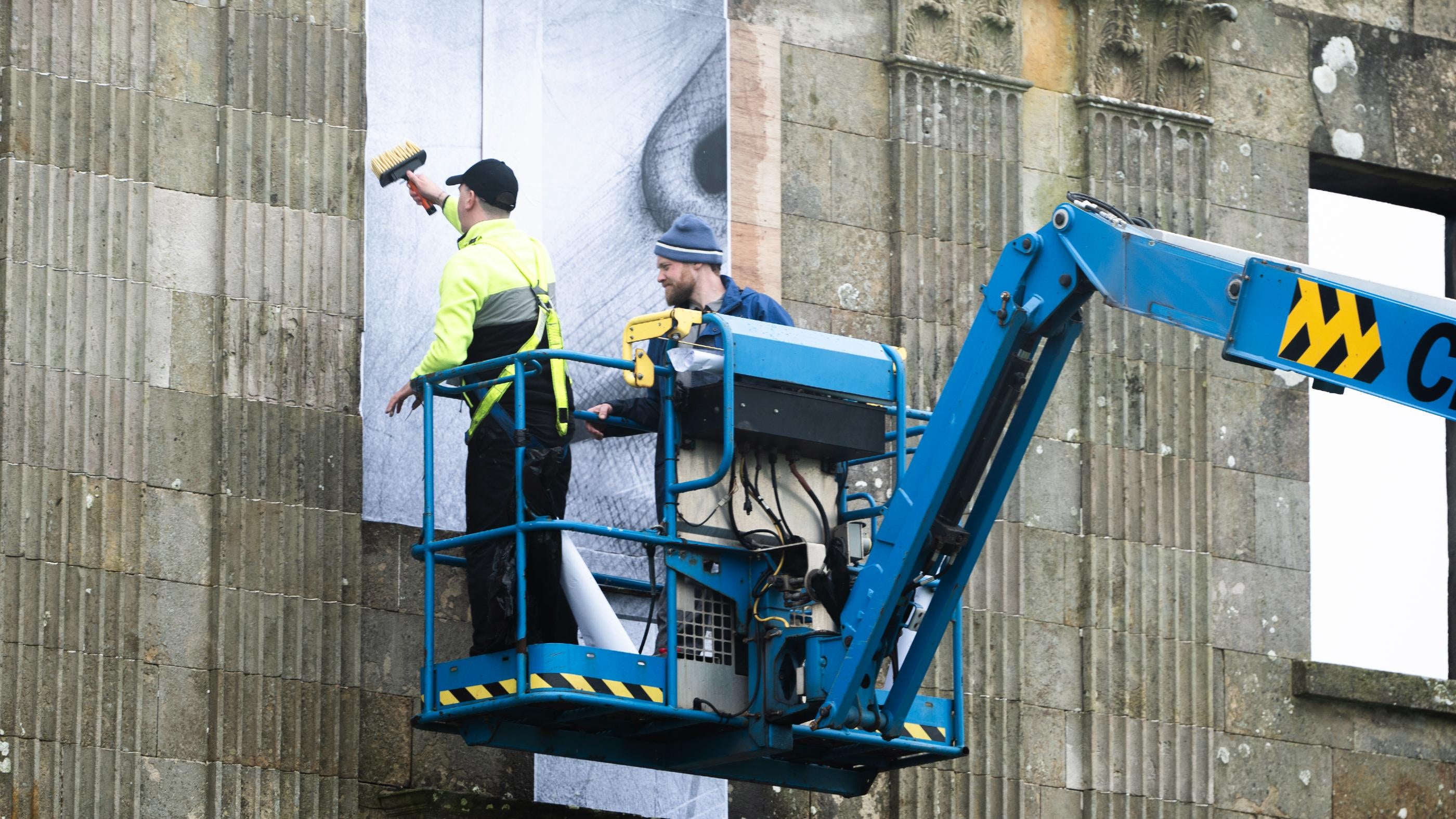 An image of Joe Caslin installing the artwork at Downhill House.