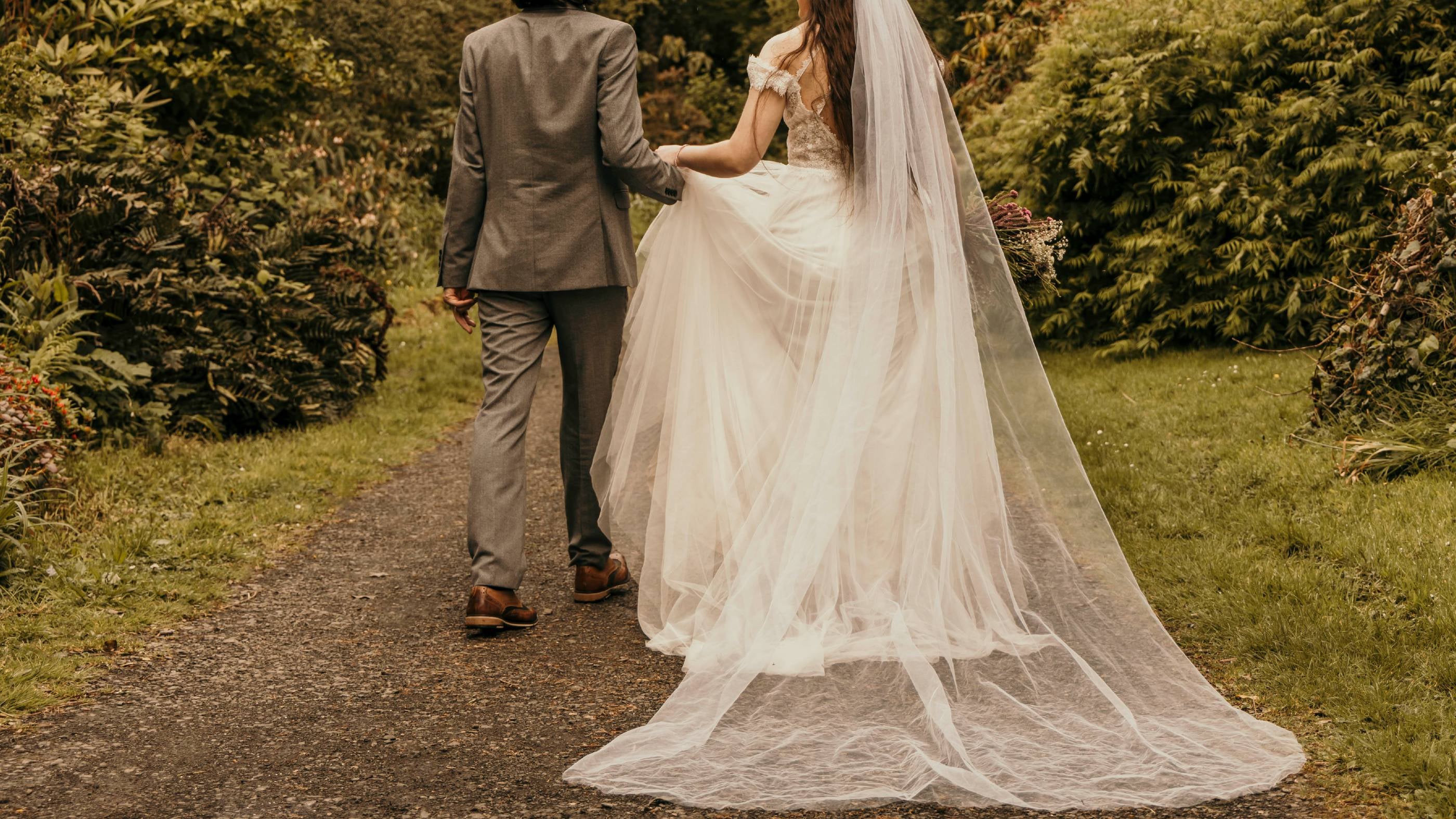 An image of a bride and groom walking away from the camera.