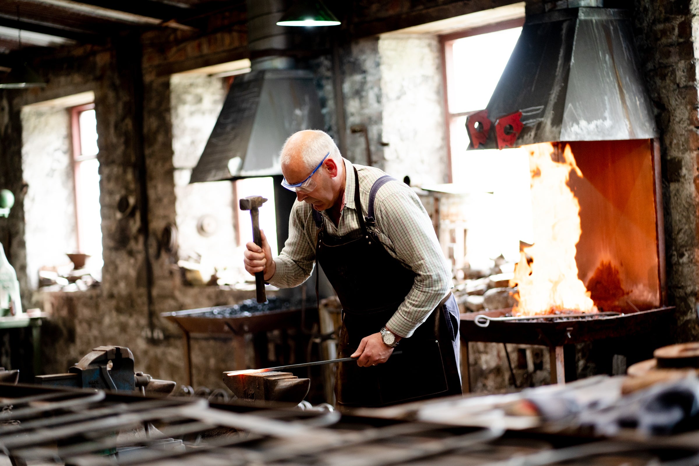 A blacksmith toils away in the forge