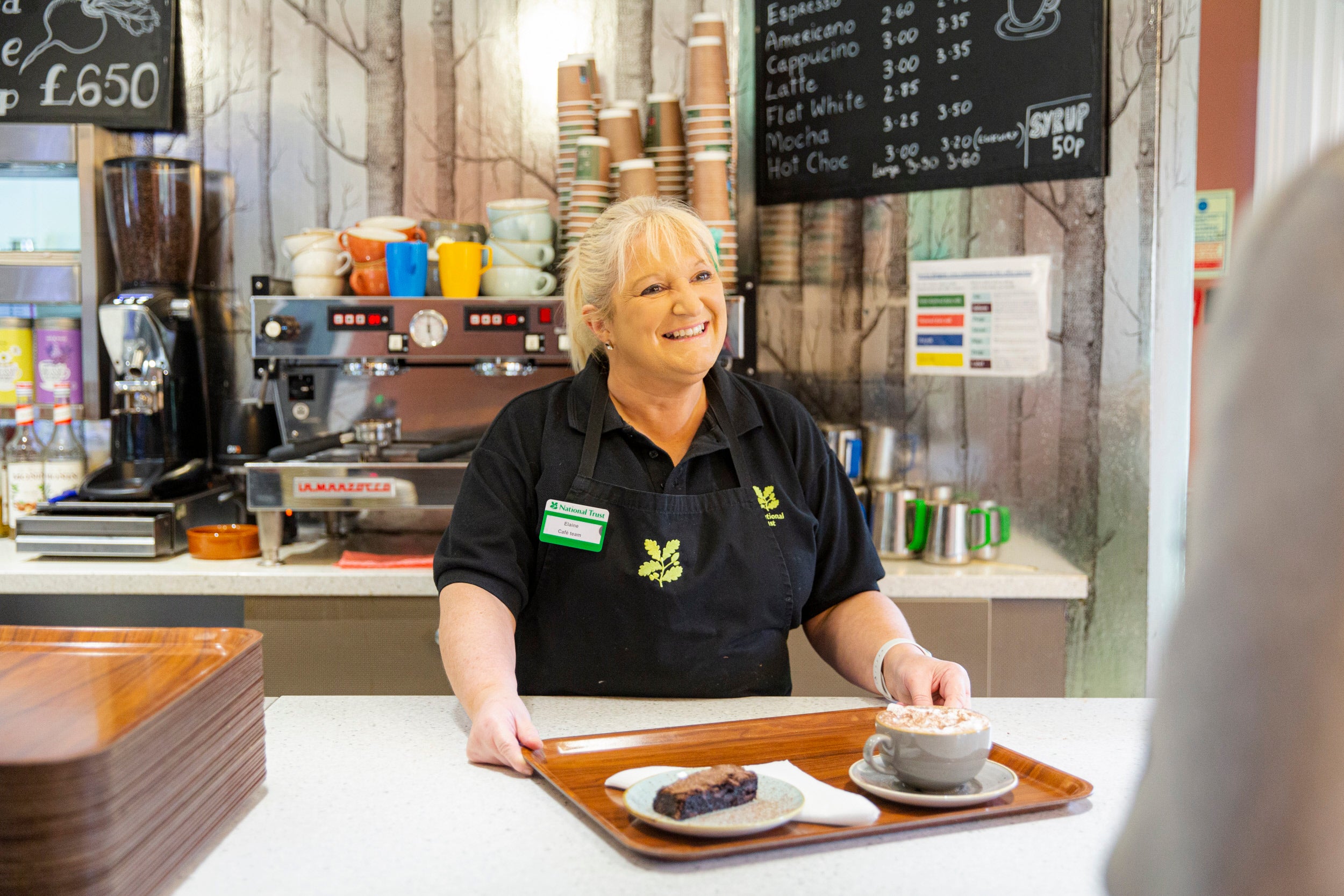 Catering assistant serving refreshments in the cafe at Rowallane Garden