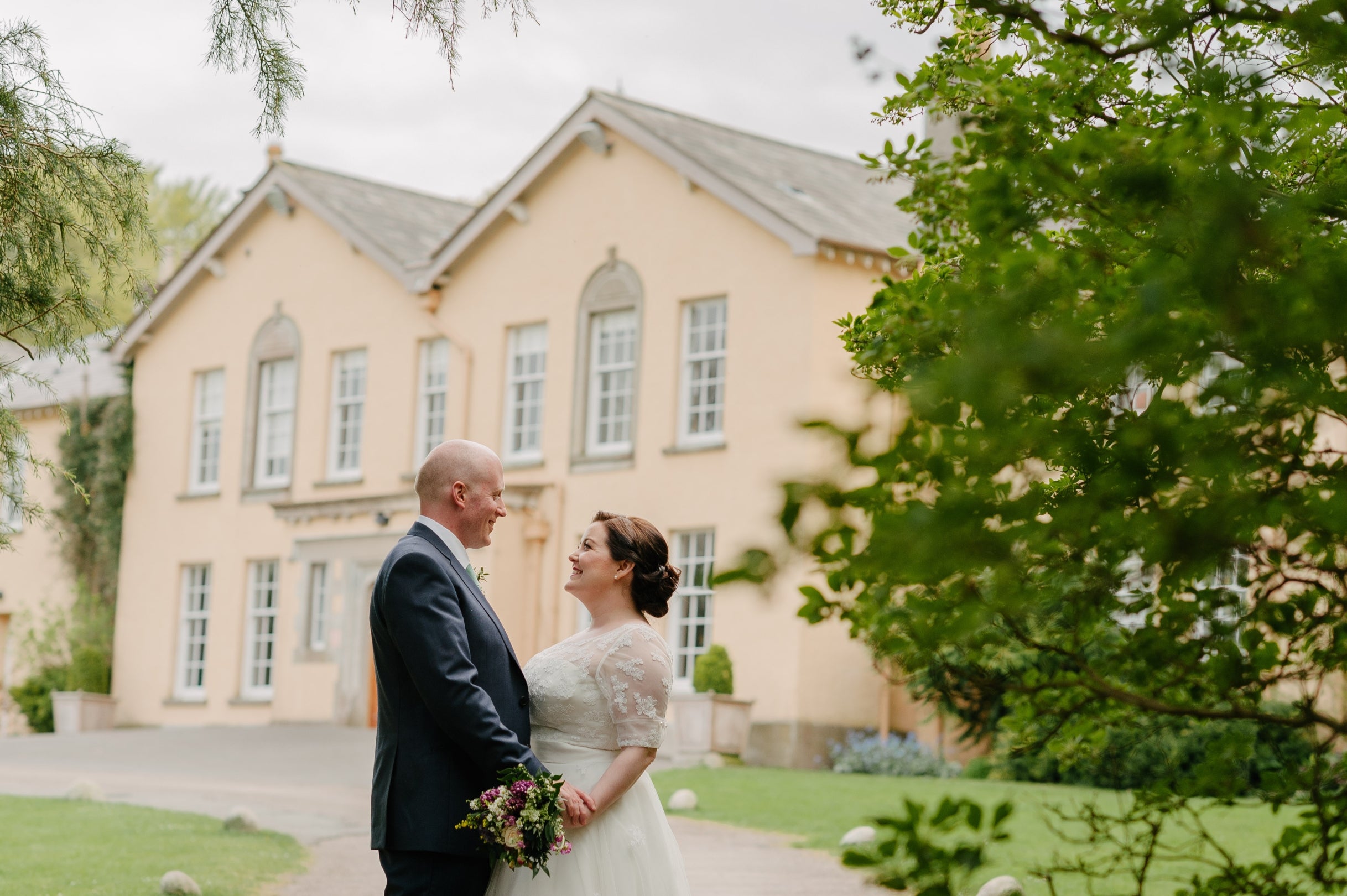 Newlyweds pictured with Rowallane House in background at Rowallane Garden County Down