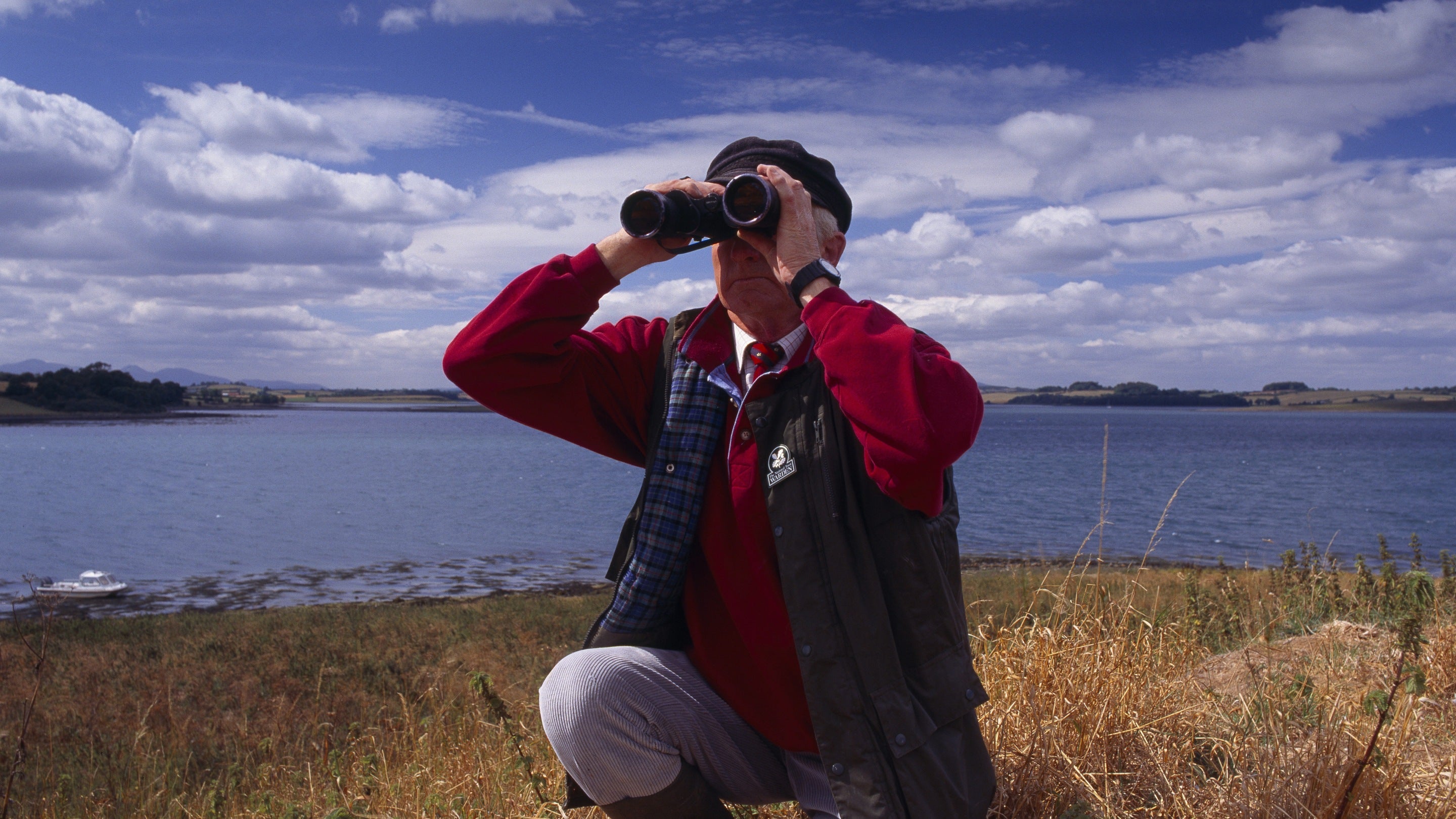 Staff member checking birds on the lough at Strangford Lough, County Down, Northern Ireland