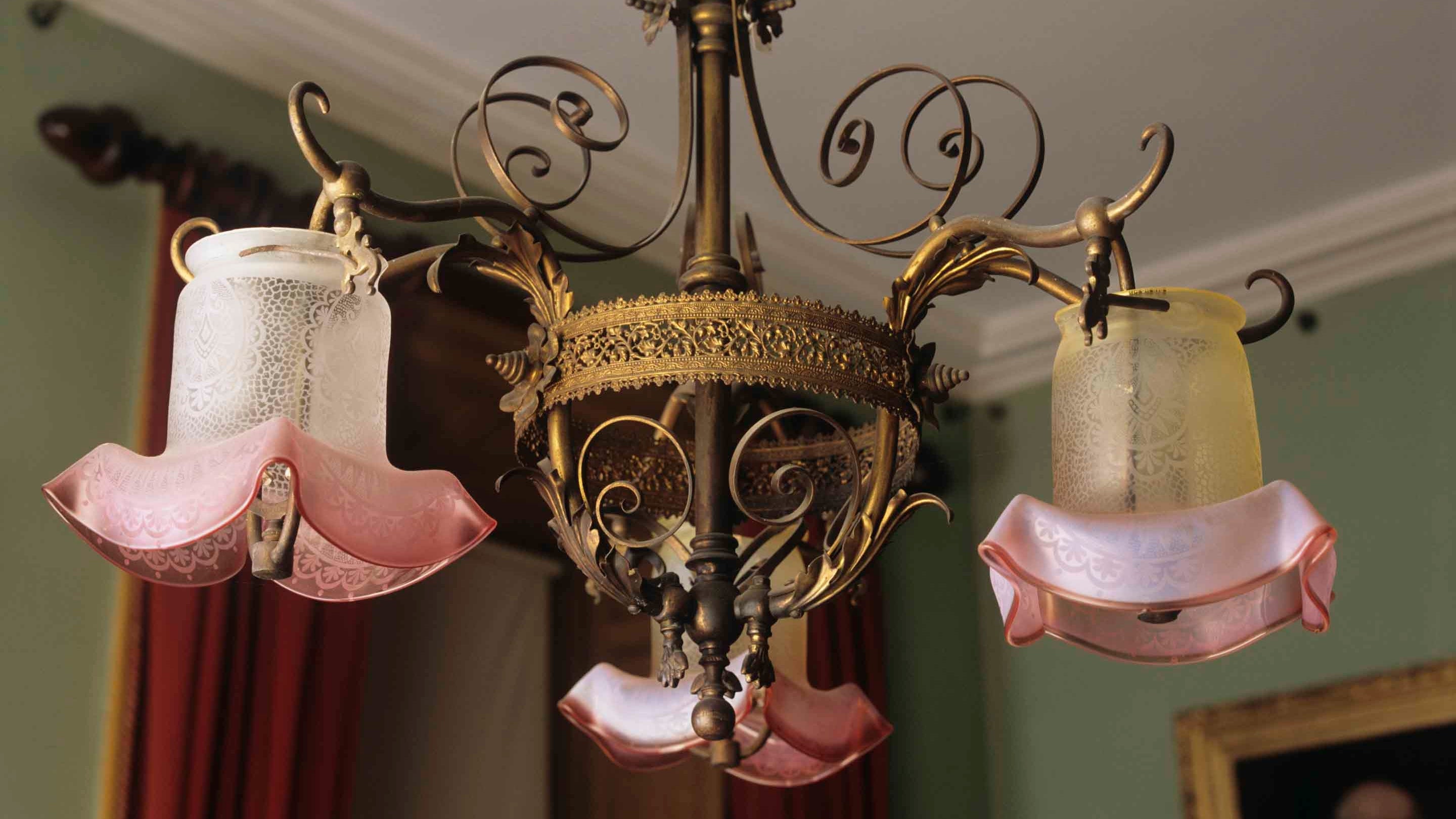 An ornate three-arm gasolier with pink flushed, etched glass shades in the Study at The Argory, County Armagh, Northern Ireland