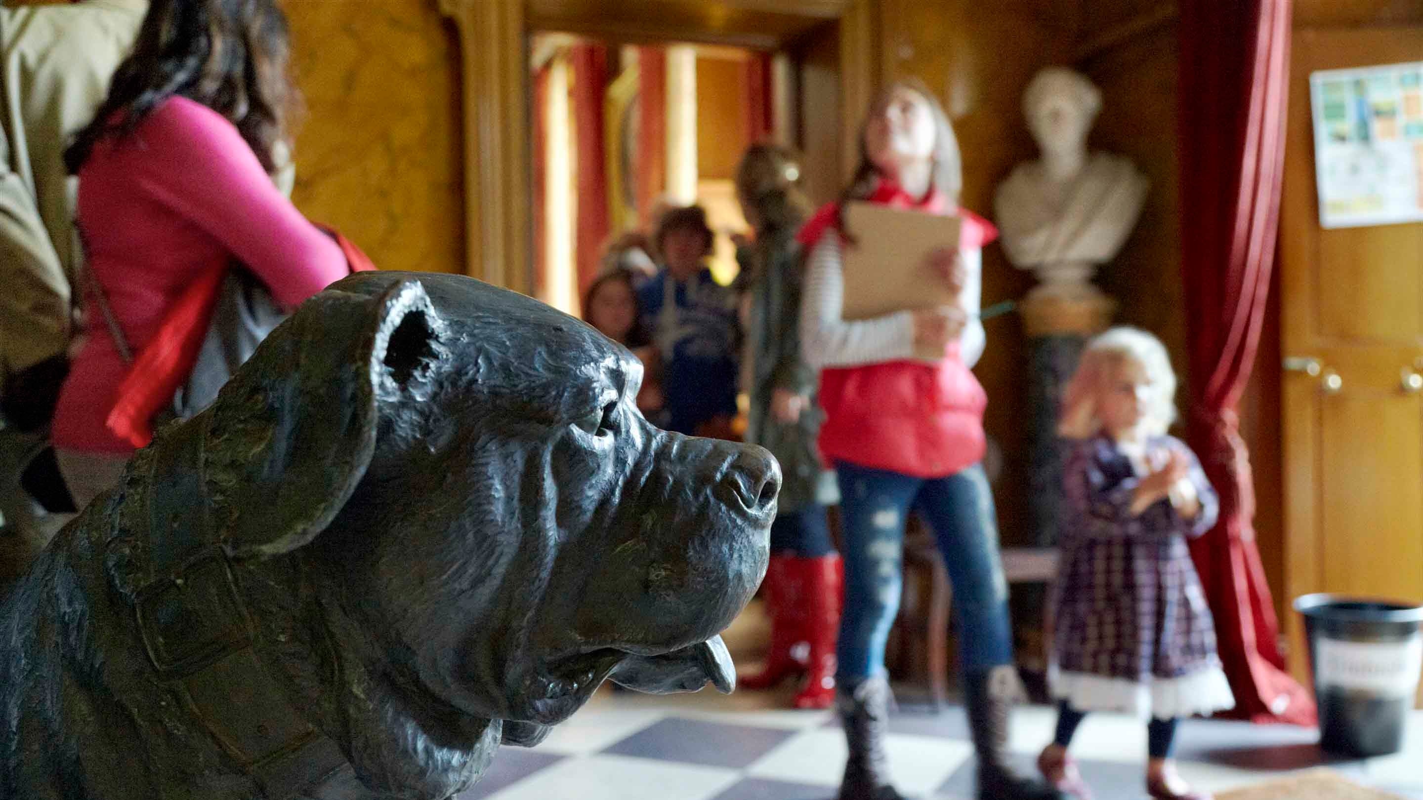 Visitors in the West Hall with a bronze statue of a dog at The Argory, County Armagh, Northern Ireland