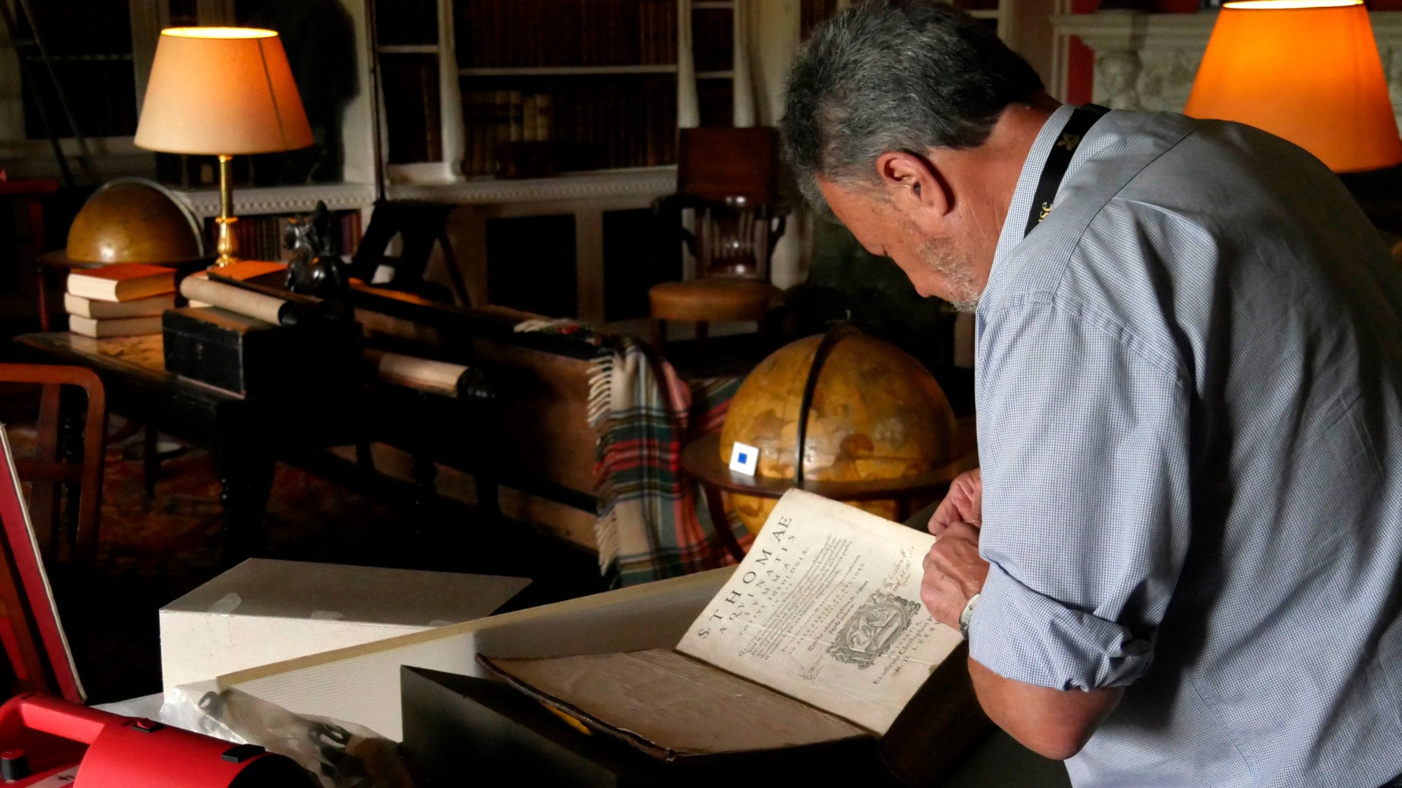 Book conservation volunteer in action mending a historic book at Belton House, Lincolnshire