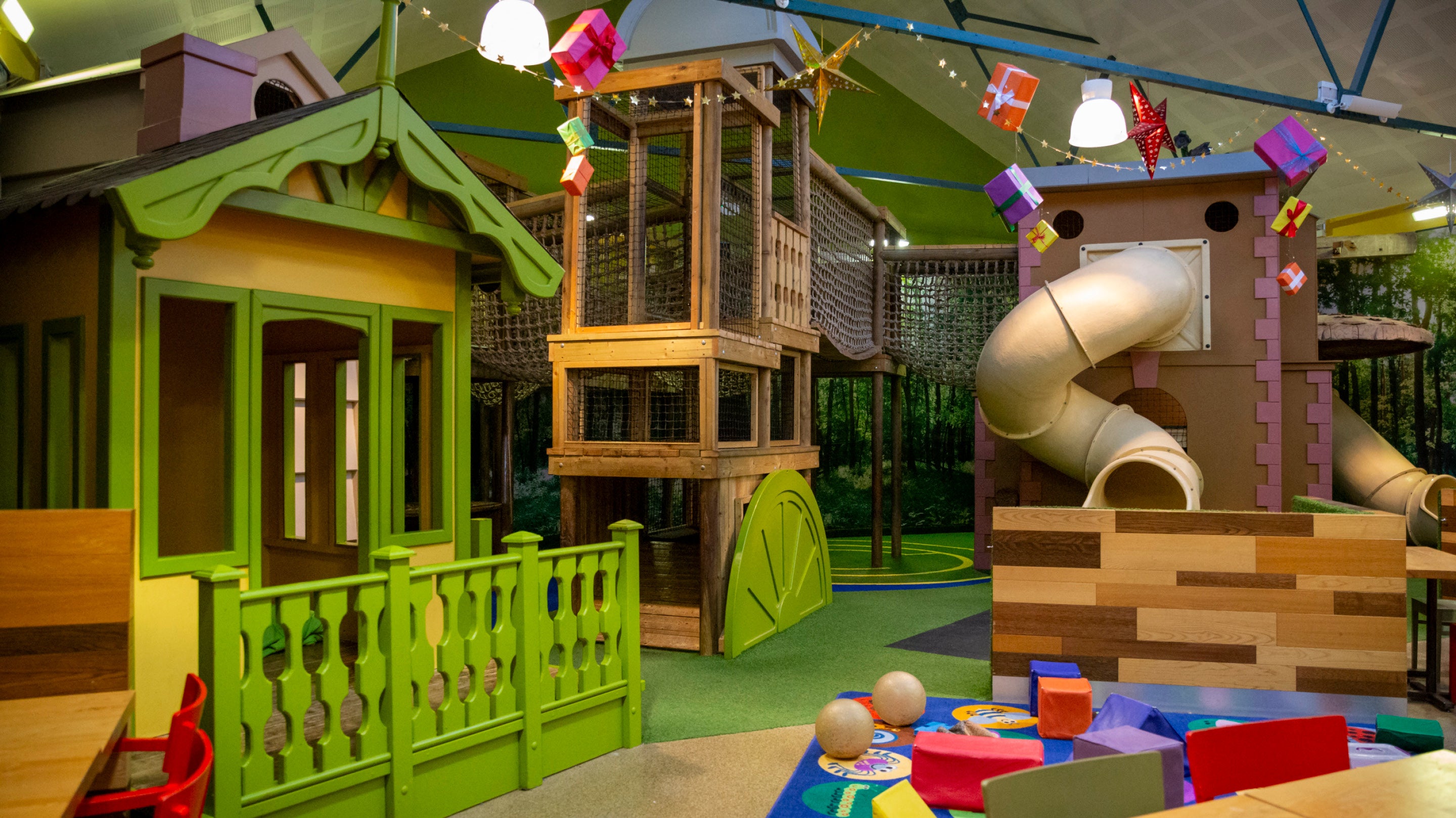 The Ride Indoor Play Café at Belton with colourful play equipment including a little green and yellow house, a slide and rope bridges.