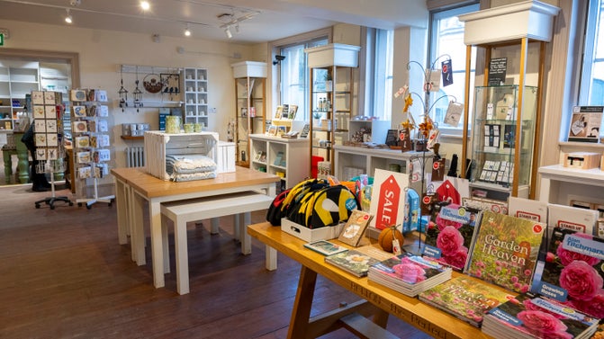 The Old Coach House Shop upper gallery with tables of products.