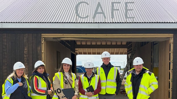 Project partners standing beside the new café building at Sandilands Nature Reserve as construction progresses.