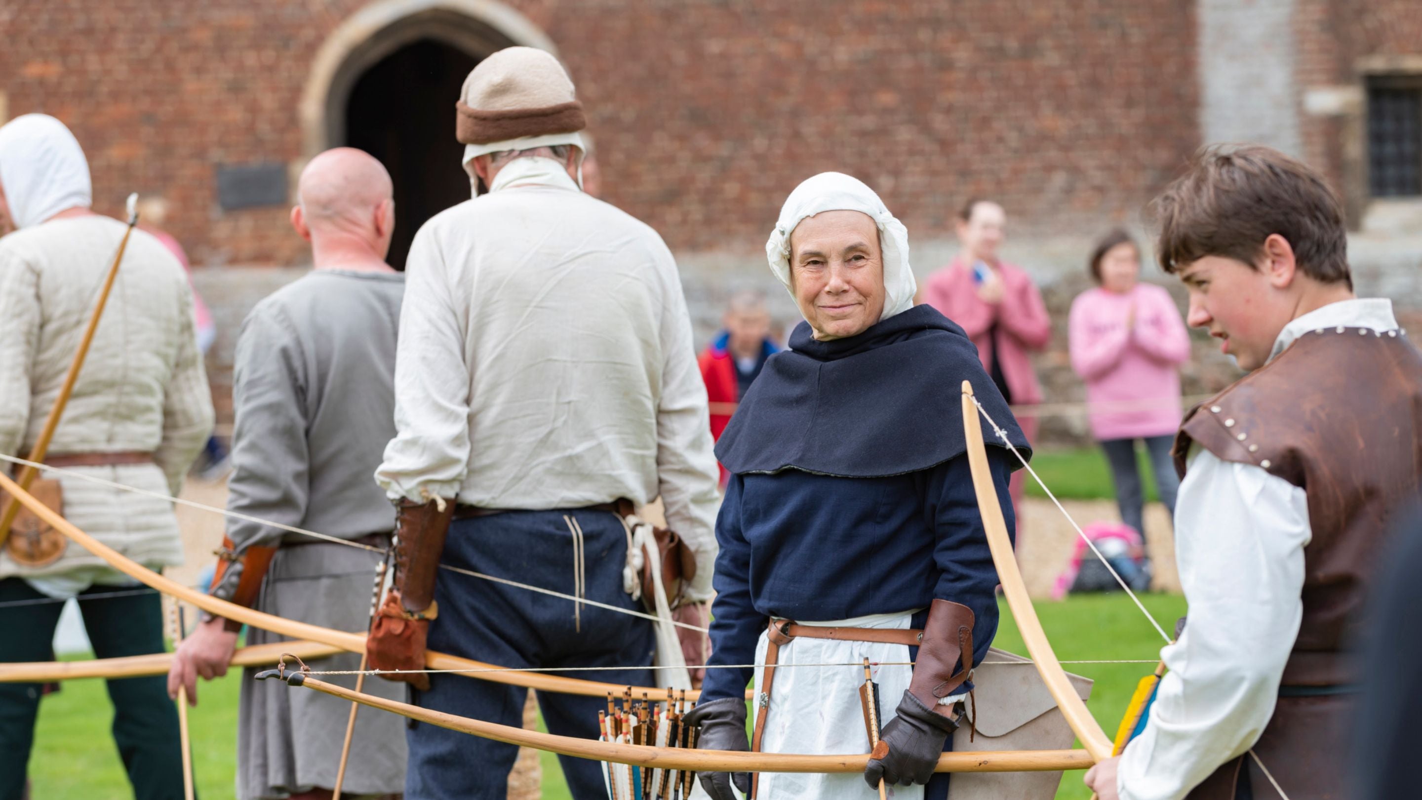 Row of archers at an archery demonstration at the Medieval Festival at Tattershall Castle, Lincolnshire