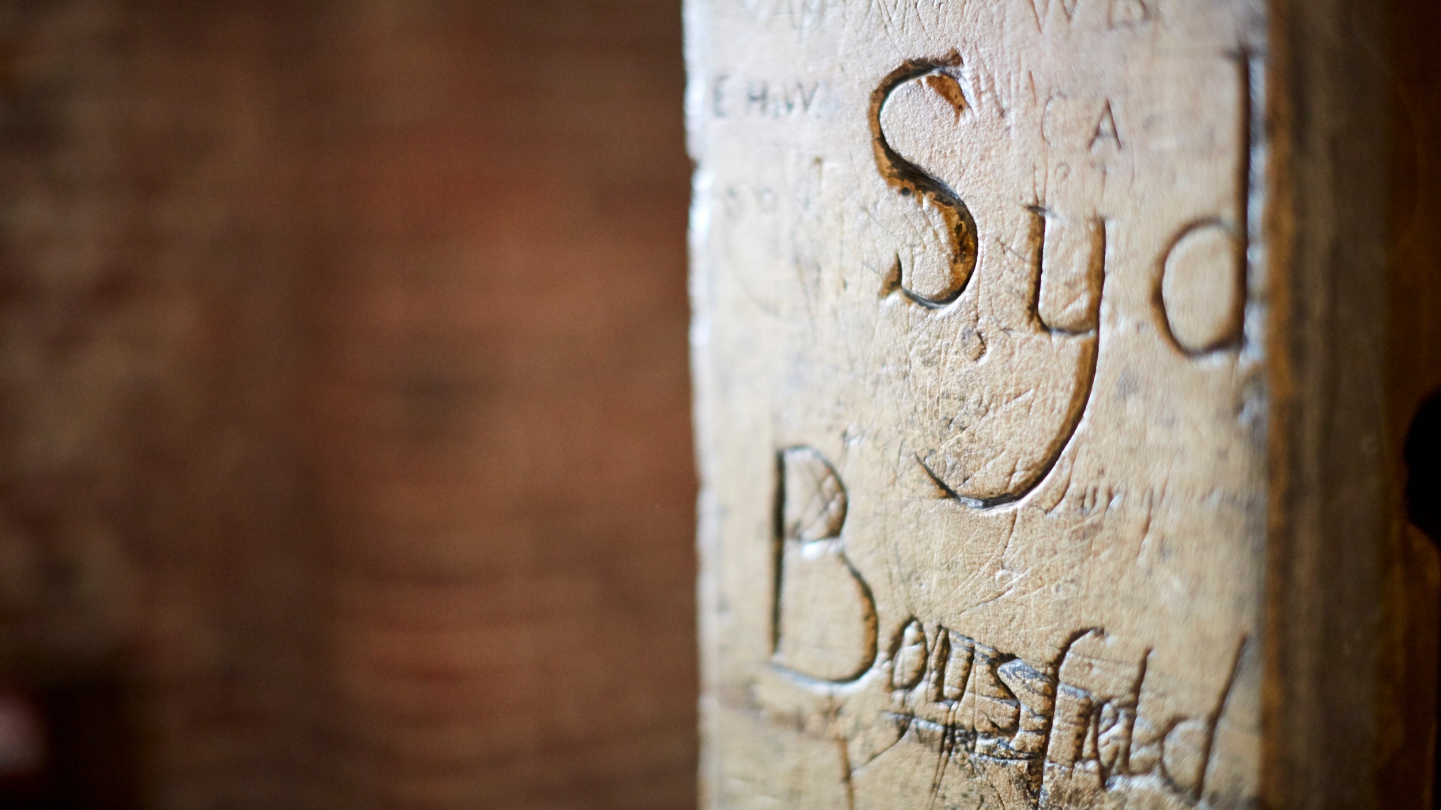 A close up of graffiti carved into the stonework at Tattershall Castle