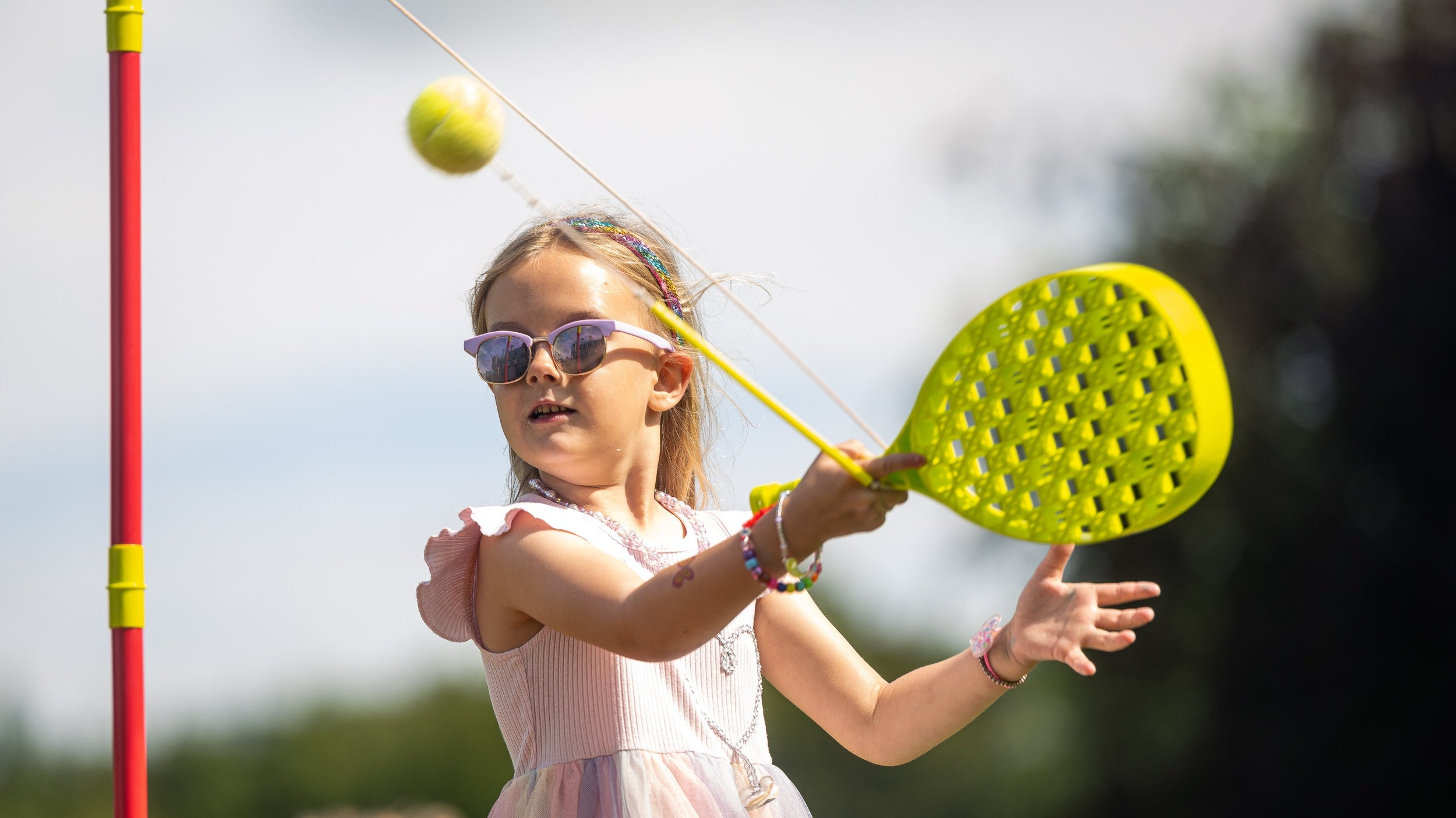 Girl hitting a swing ball with a yellow bat