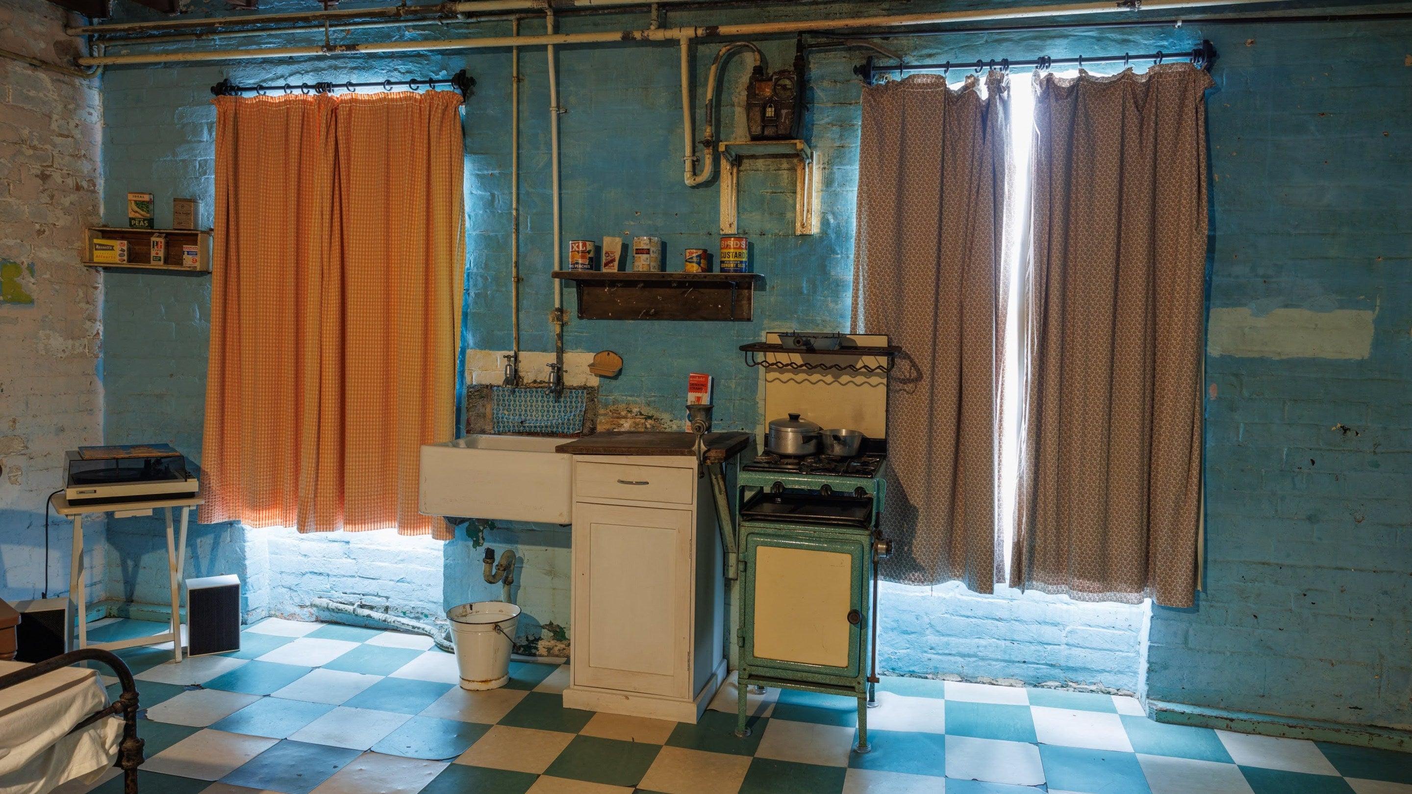 The kitchen area in the bedsit with cooker and windows