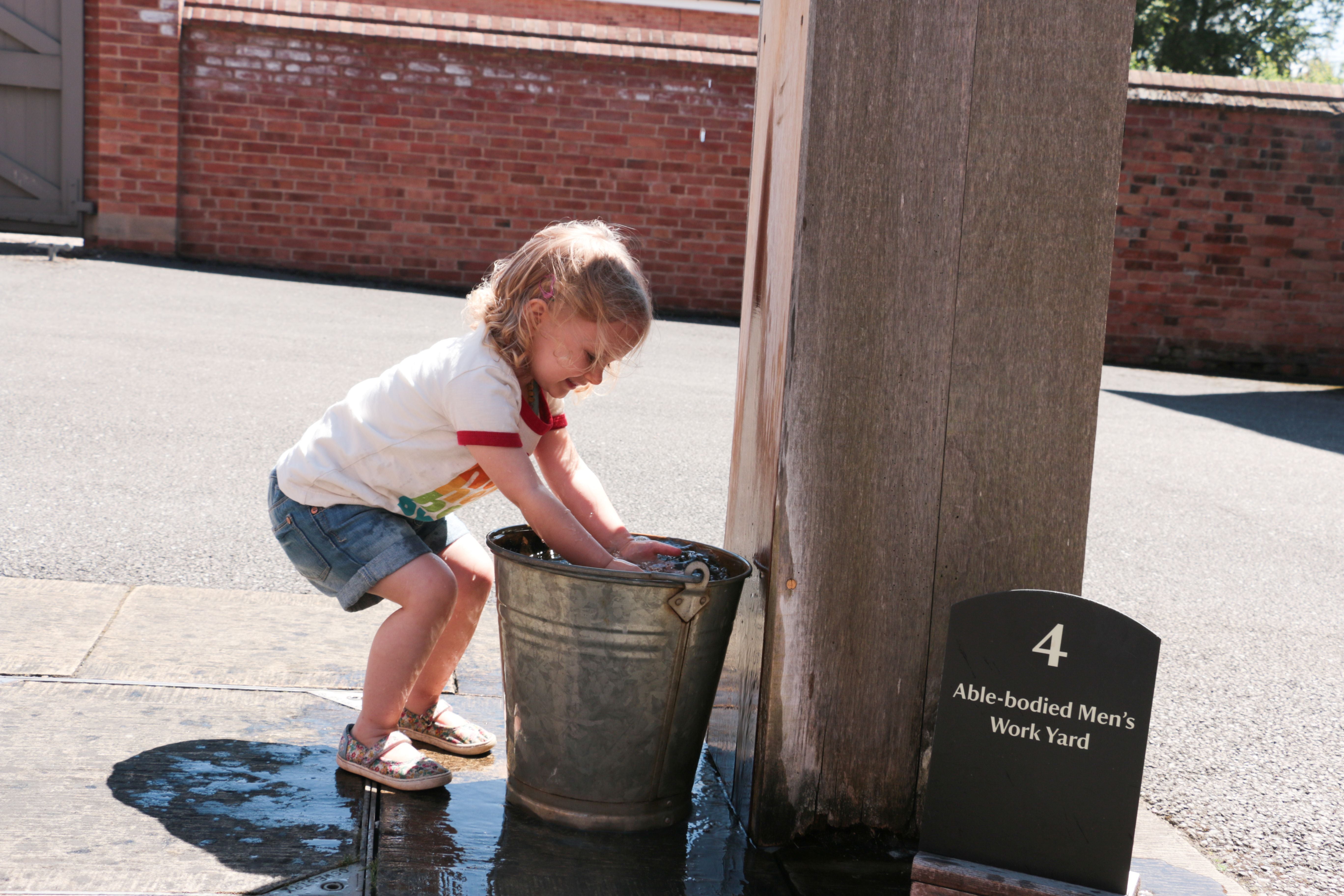 Young girl using a waterpump