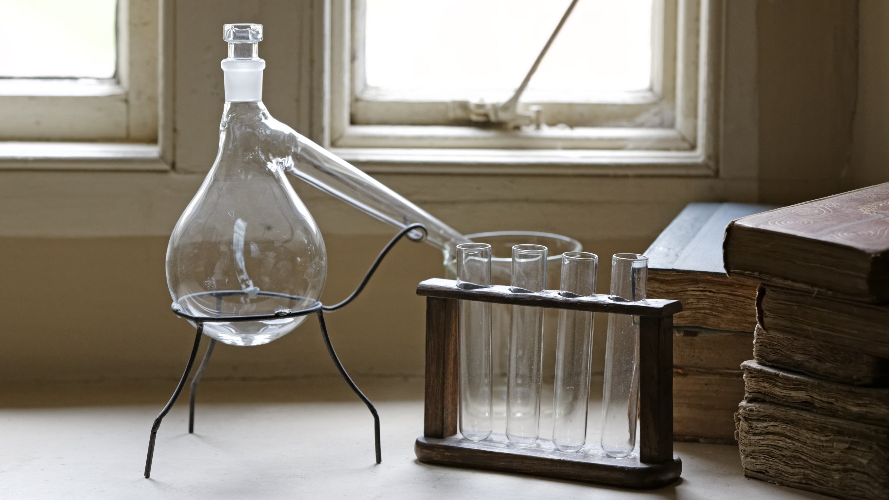 A selection of scientific instruments on a window sill beside a pile of books at Sir Isaac Newton's home, Woolsthorpe Manor, Lincolnshire.