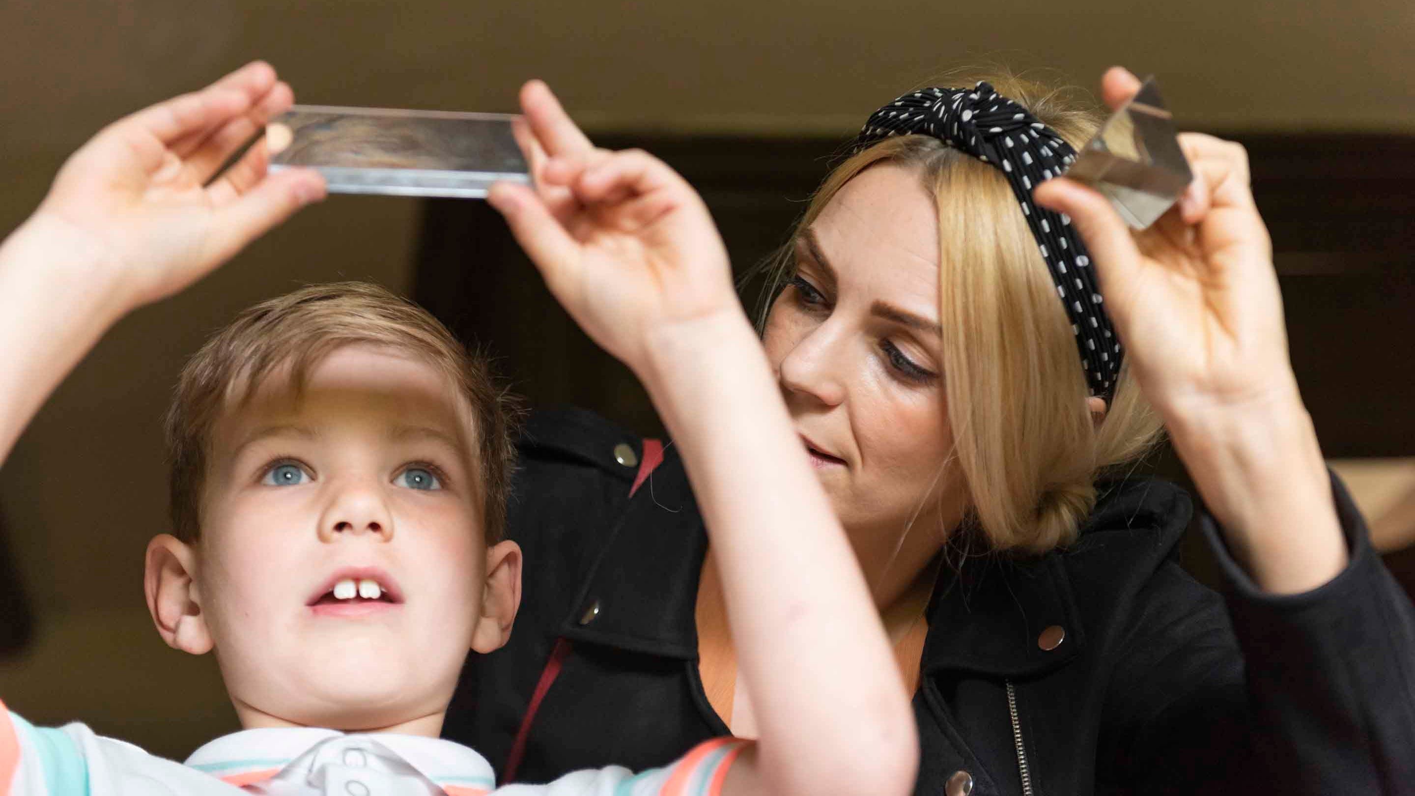 Young boy looks at light through at prism in Isaac Newton's childhood home