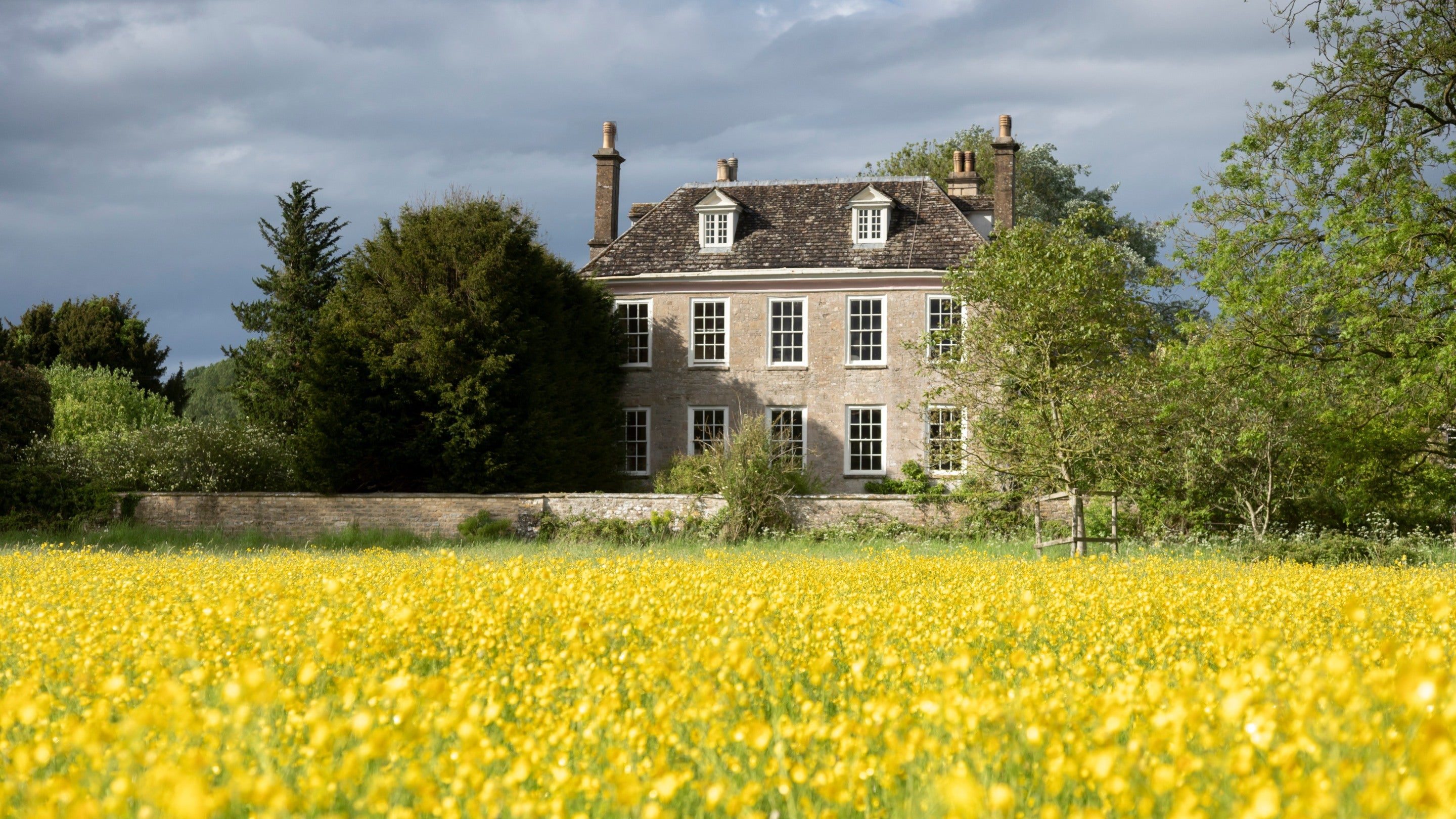 View across a field of rapeseed towards Buscot Old Parsonage, Oxfordshire