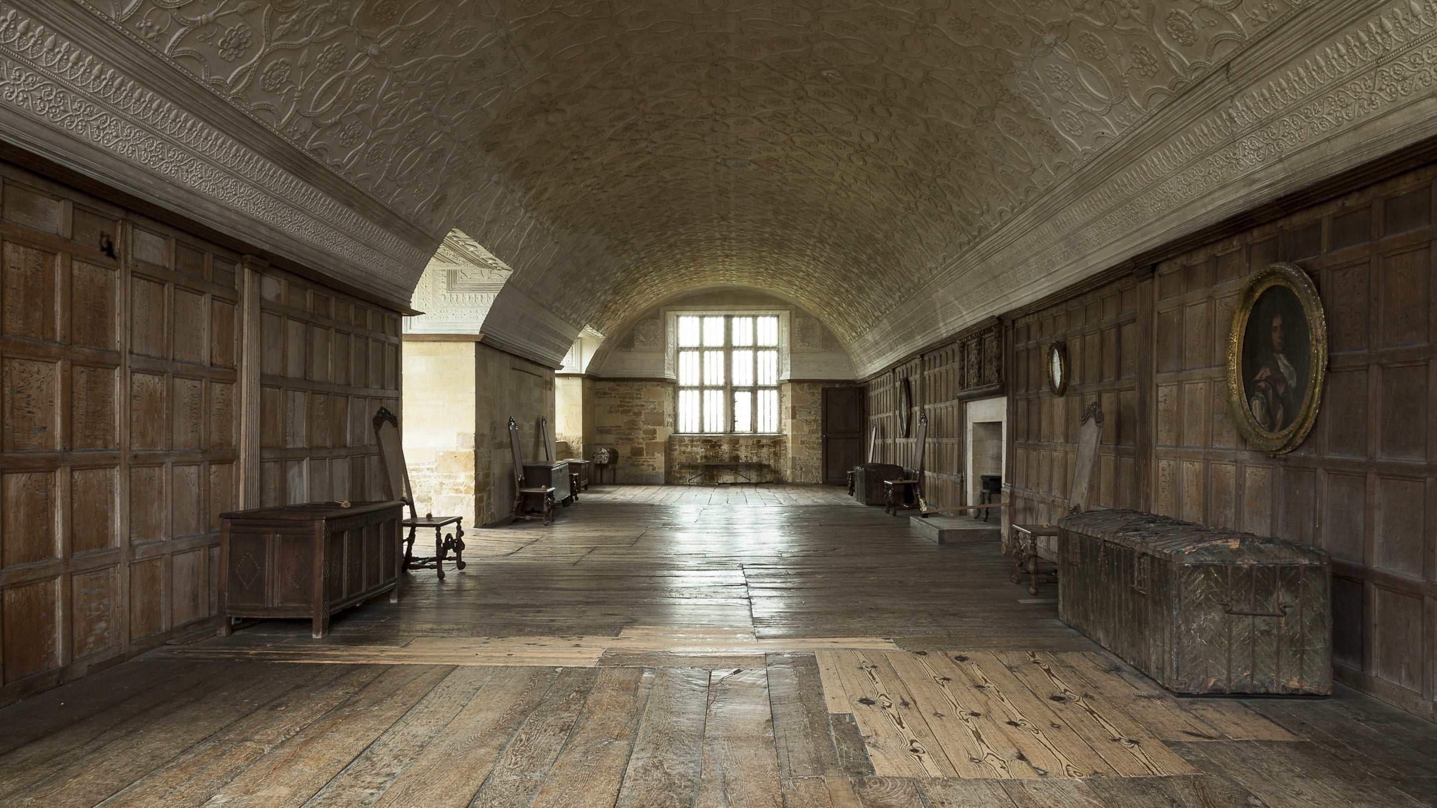 The Long Gallery at Chastleton House, Oxfordshire, with a wooden floor, wood-panelled walls and a barrel-vaulted ceiling. A rare gem of a Jacobean country house, Chastleton House was built between 1607 and 1612 by a prosperous wool merchant as an impressive statement of wealth and power