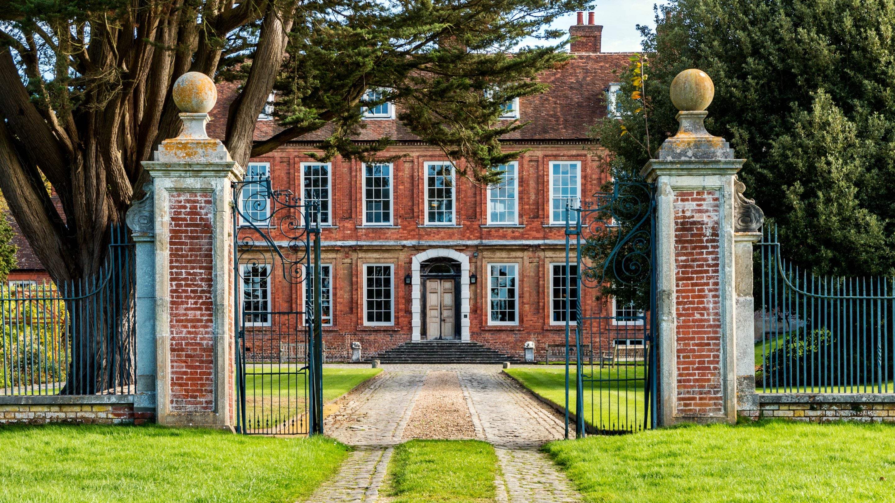 The 17th-century manor house at Bradenham seen through an ornate gate