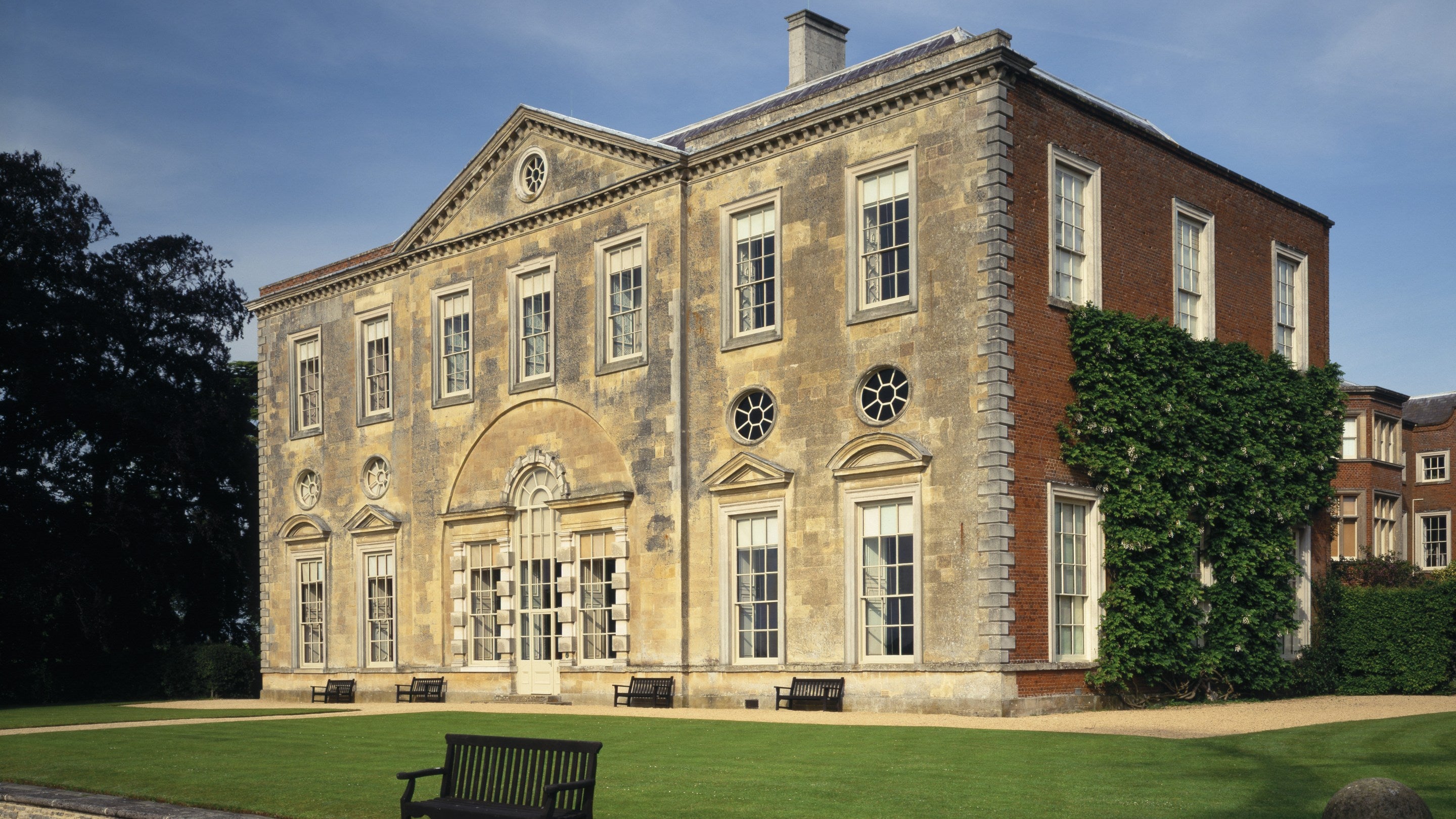 View of the West Front of Claydon House, Buckinghamshire, showing symmetrical façade of the house with a lawn in front bordered by the haha