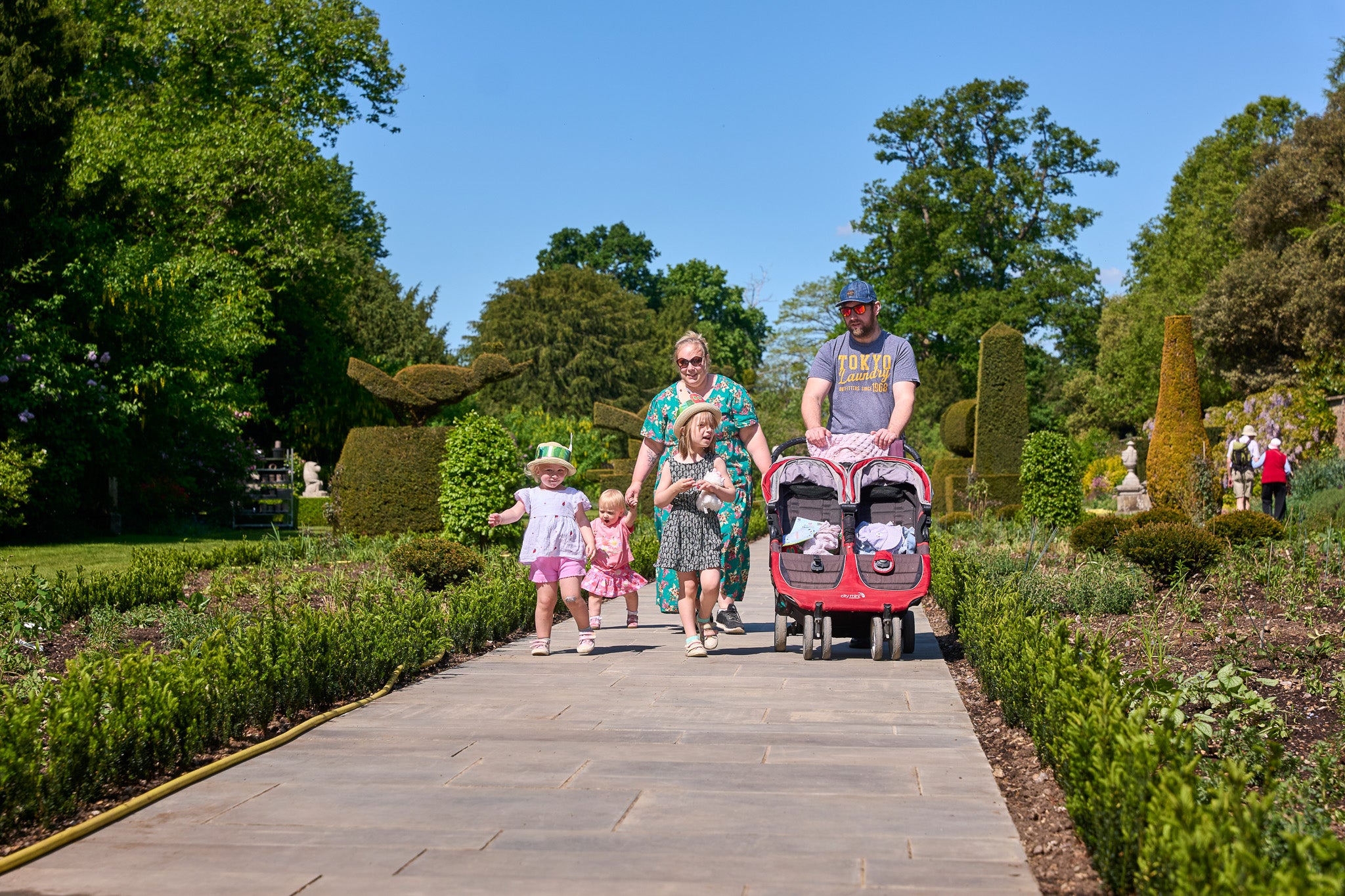 A family of five walking down the newly improved path in the Long Garden at Cliveden, Buckinghamshire.