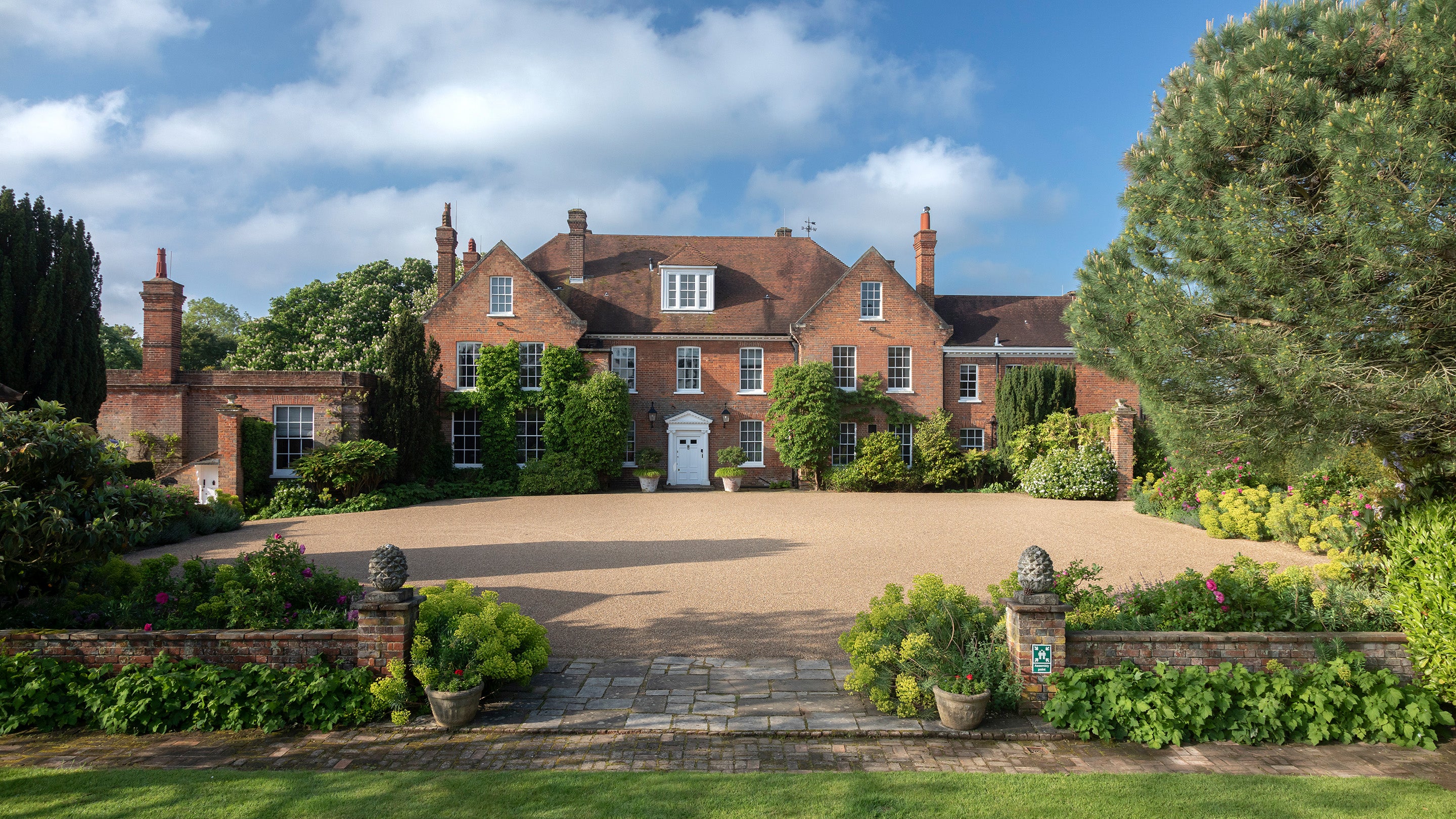 An enclosed forecourt leading to a white door.