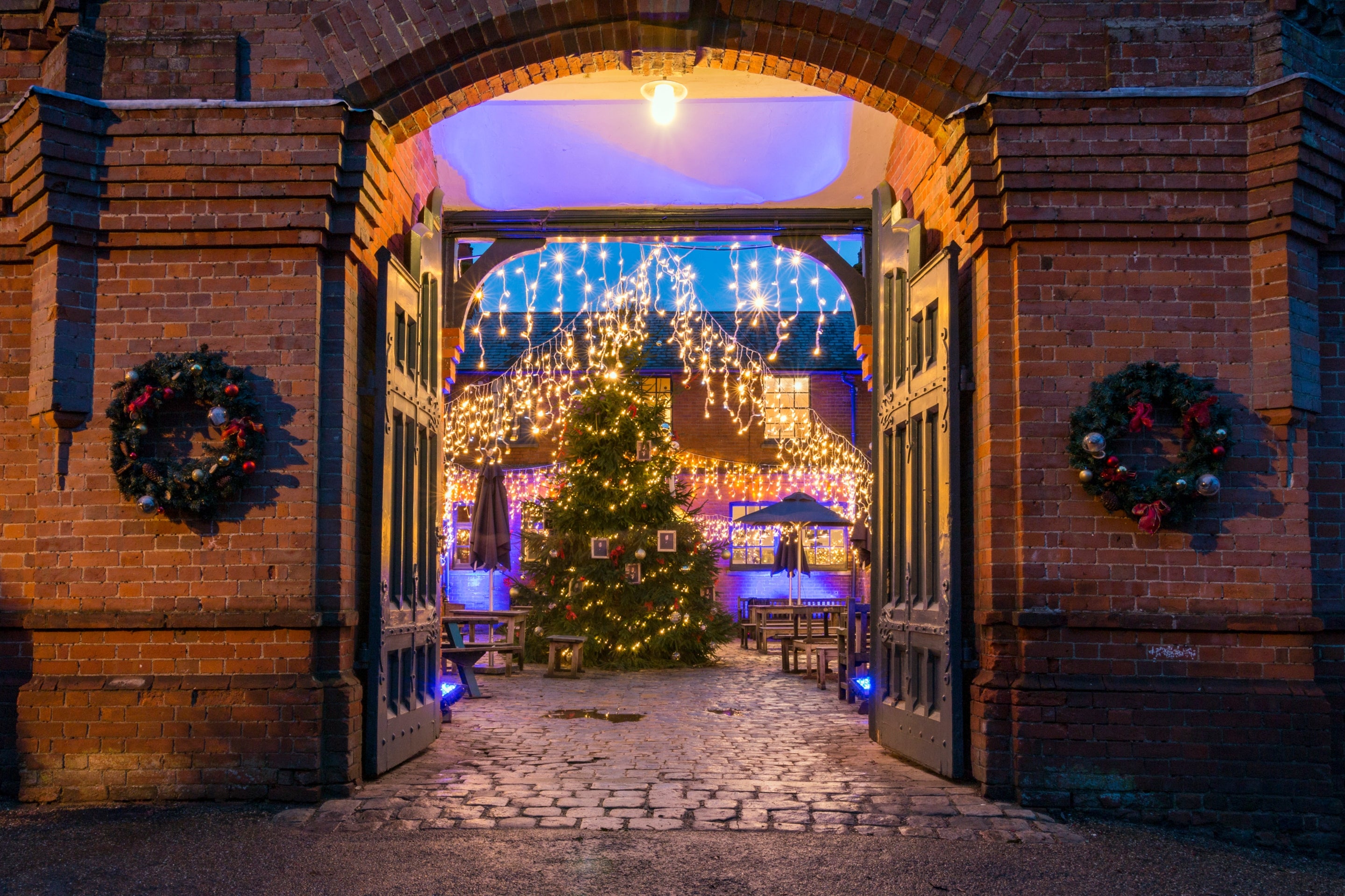 The stableyard decorated with fairy lights, Christmas tree and wreaths at Hughenden.