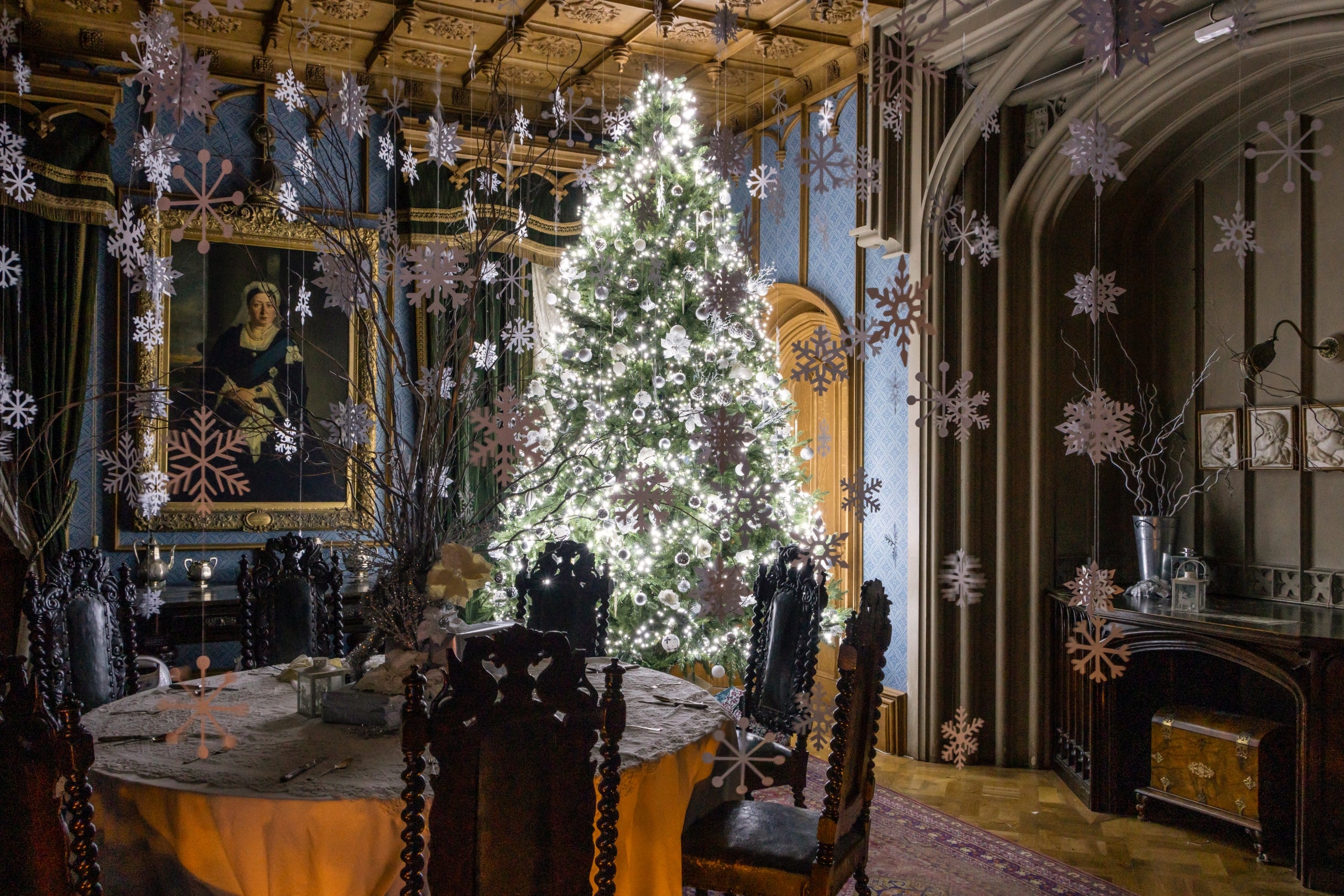 Paper snowflakes falling from the ceiling and large Christmas tree covered in cool white lights