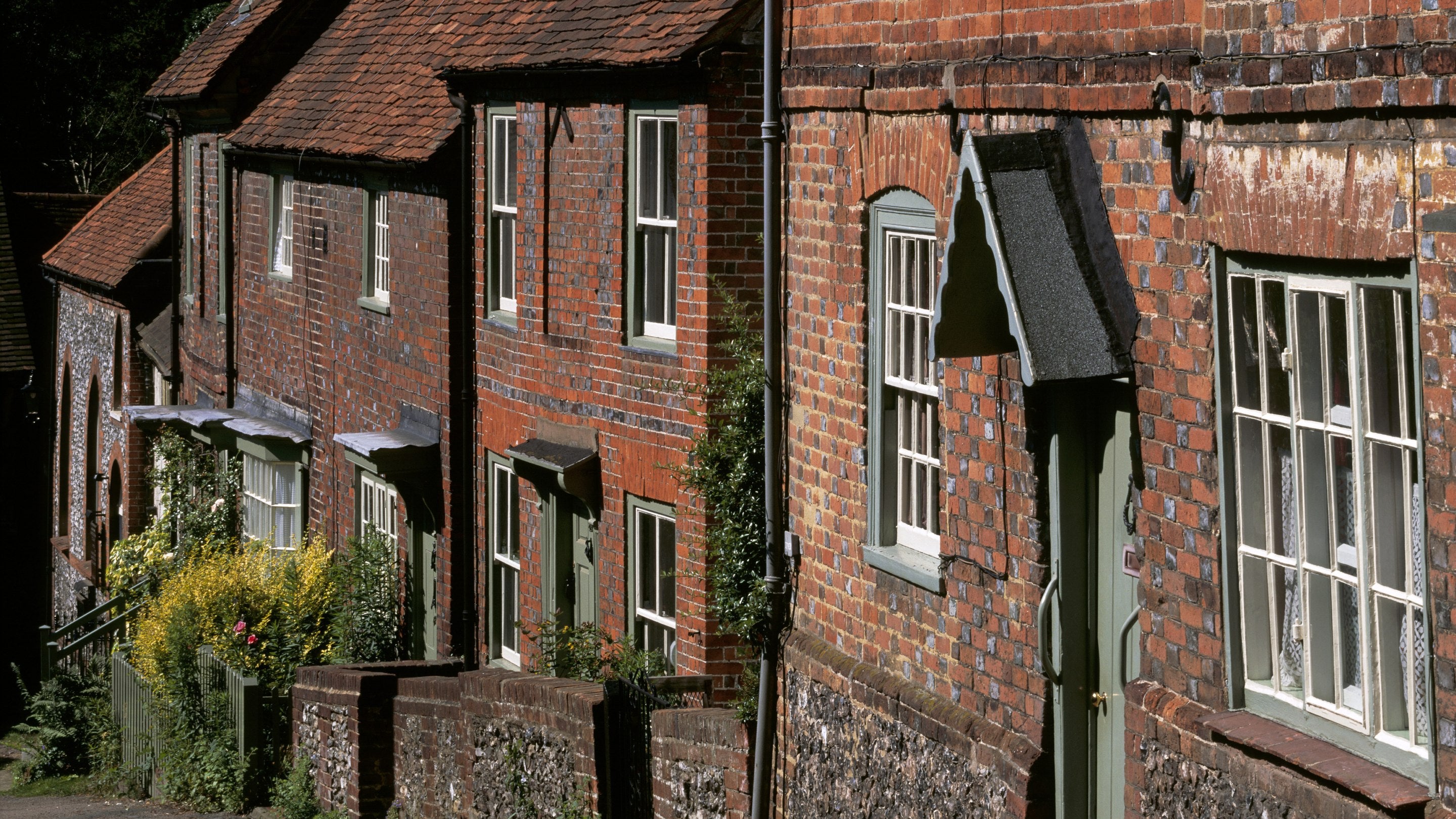 A row of red brick houses in West Wycombe Village, Buckinghamshire, which comprises examples from the 16th to 18th centuries