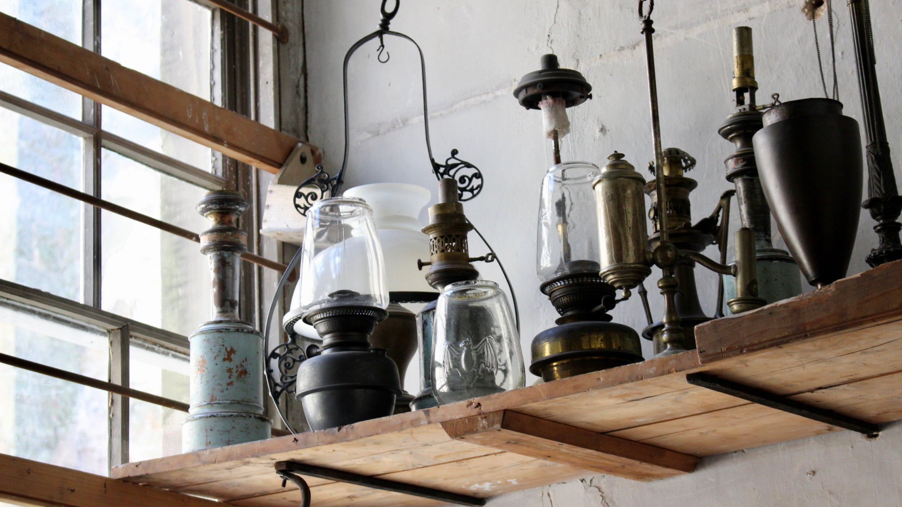 A close-up of a shelf of old and rusting lamps in the collection at Calke Abbey, known as the 'un-stately' home