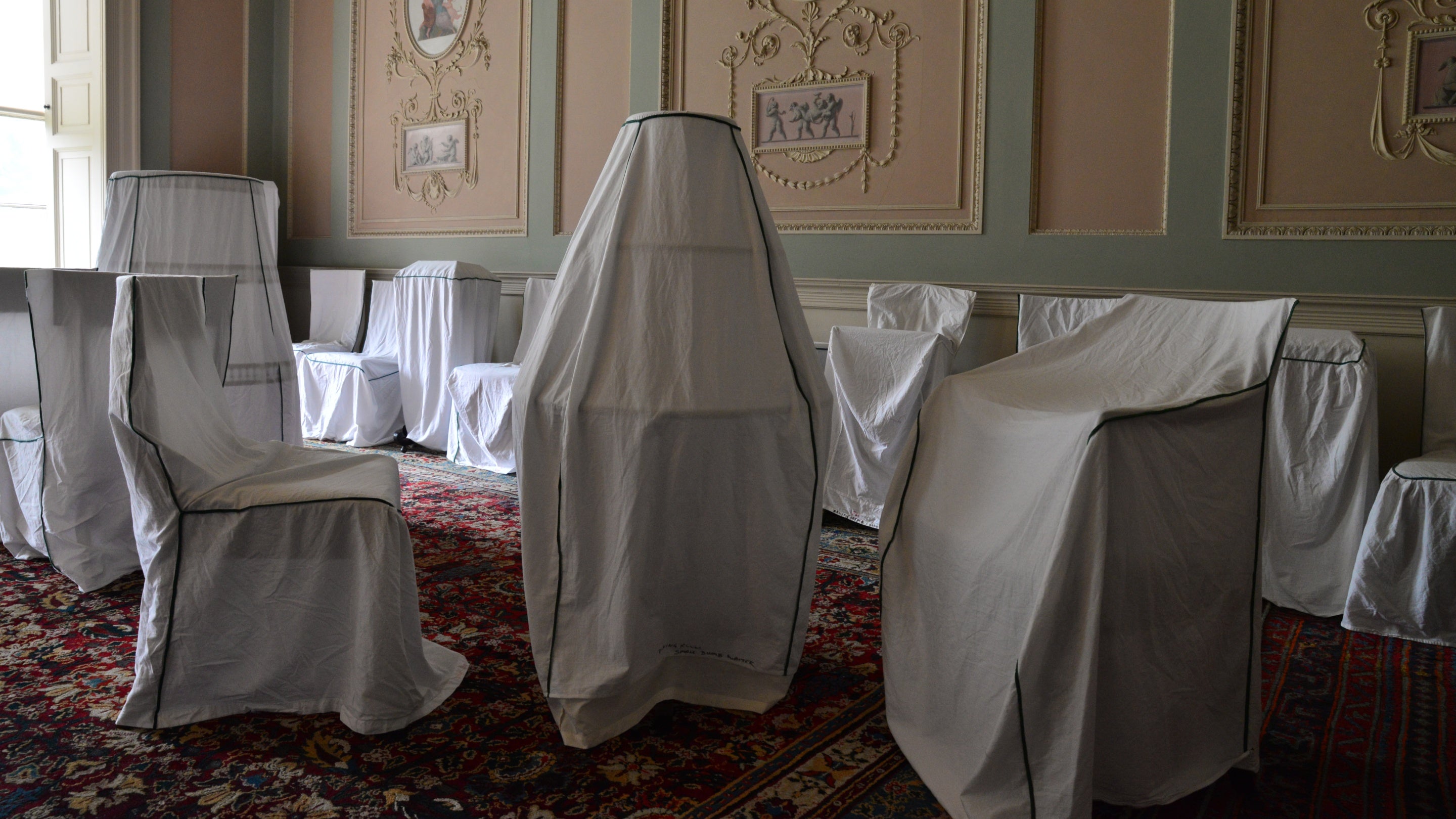 The Dining Room at Calke Abbey during the winter cleaning work, with various pieces of furniture covered in handmade fitted dust sheets