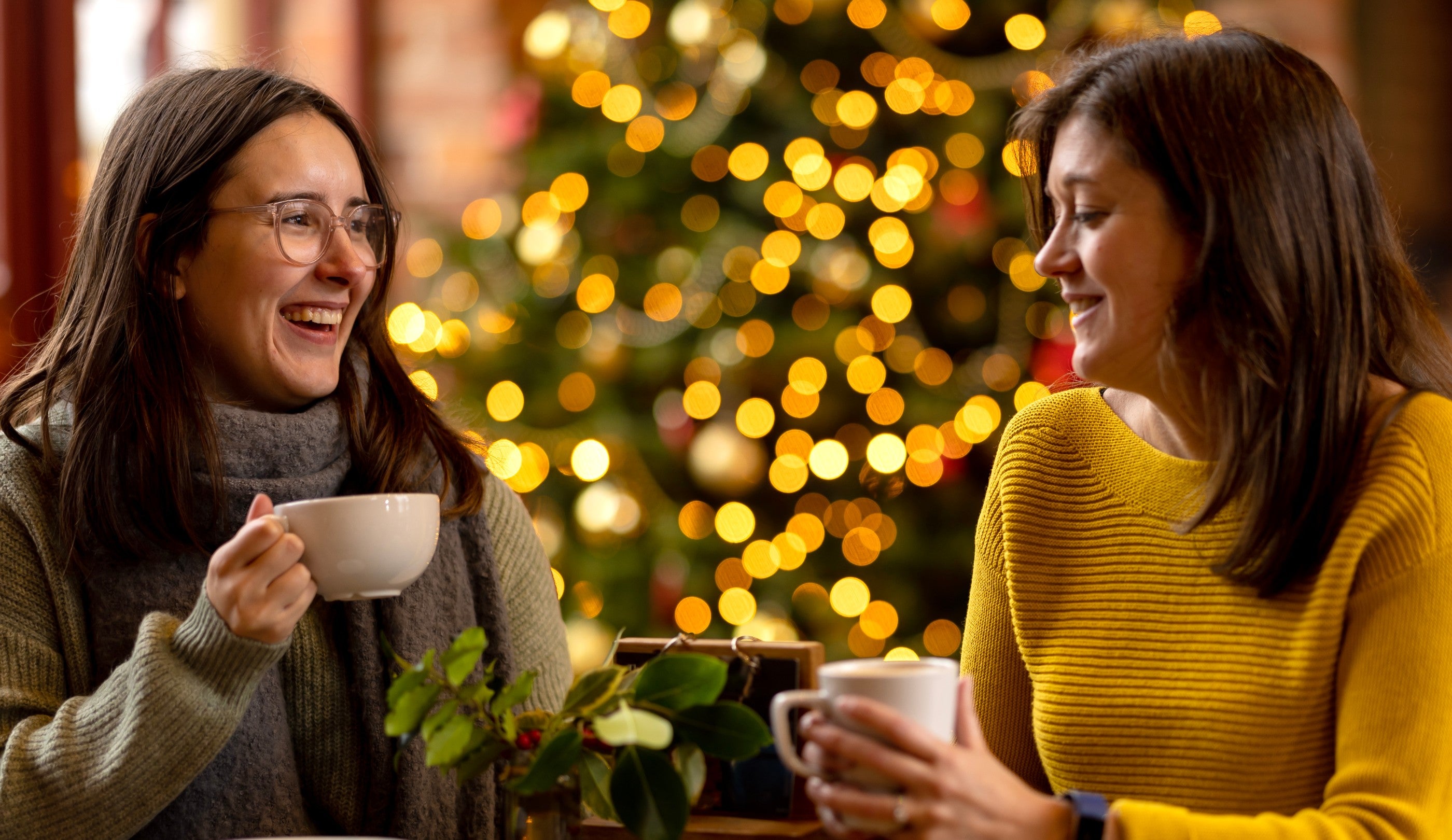Visits chatting in the cafe over a cuppa with a Christmas tree in the background