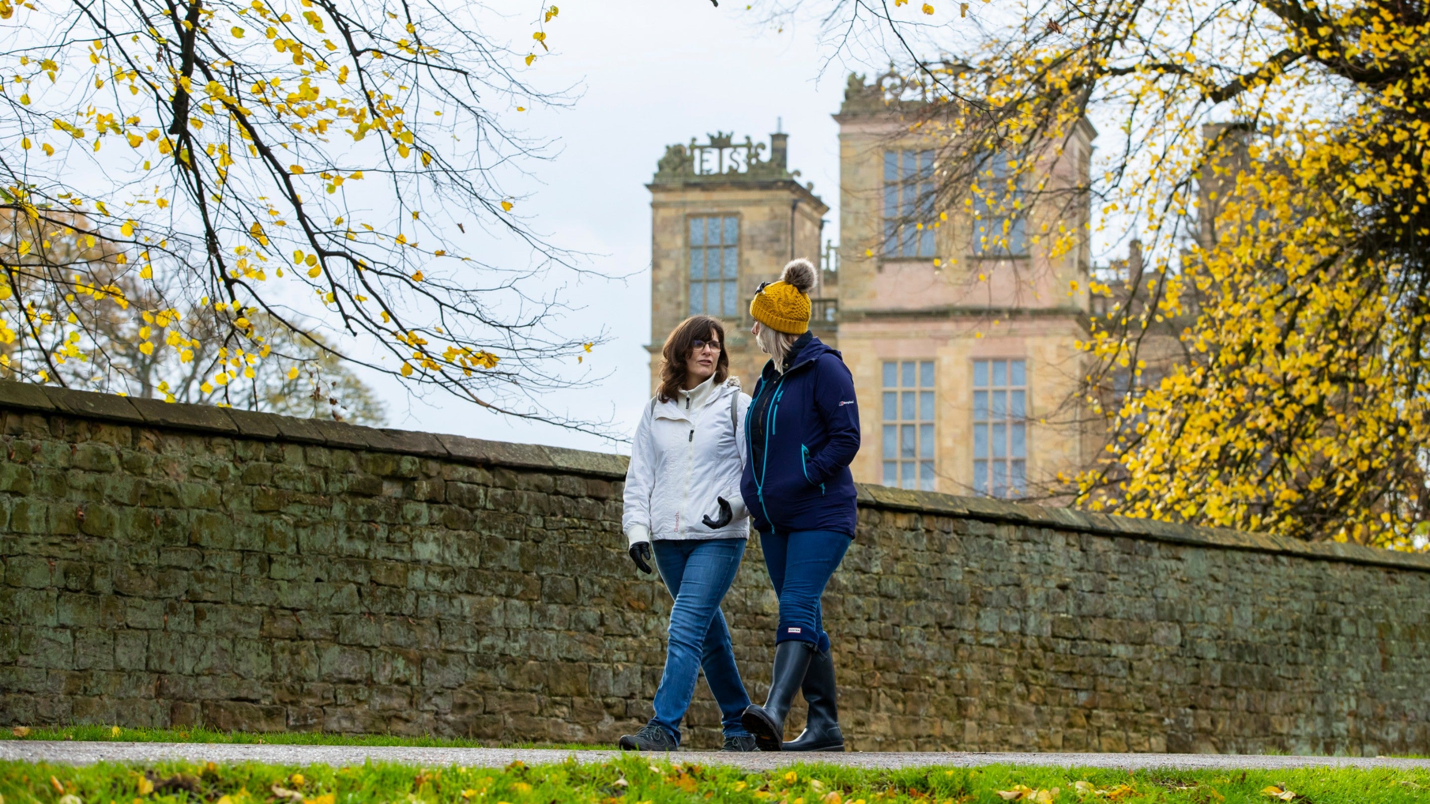 Visitors walk through the garden in autumn at Hardwick, Derbyshire