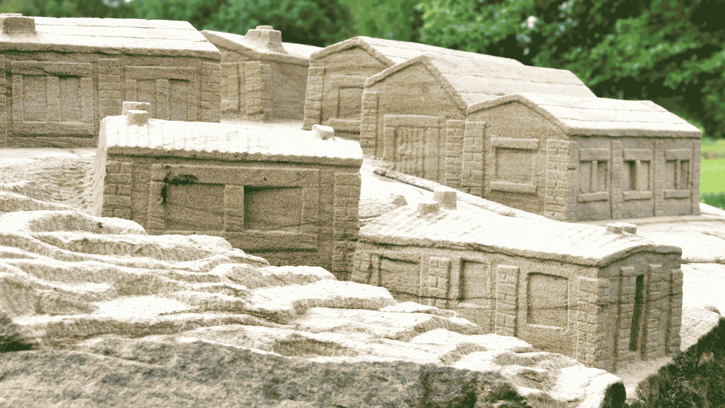 Close up image of the stone sculpture in the parkland focusing on the houses that people lived in.