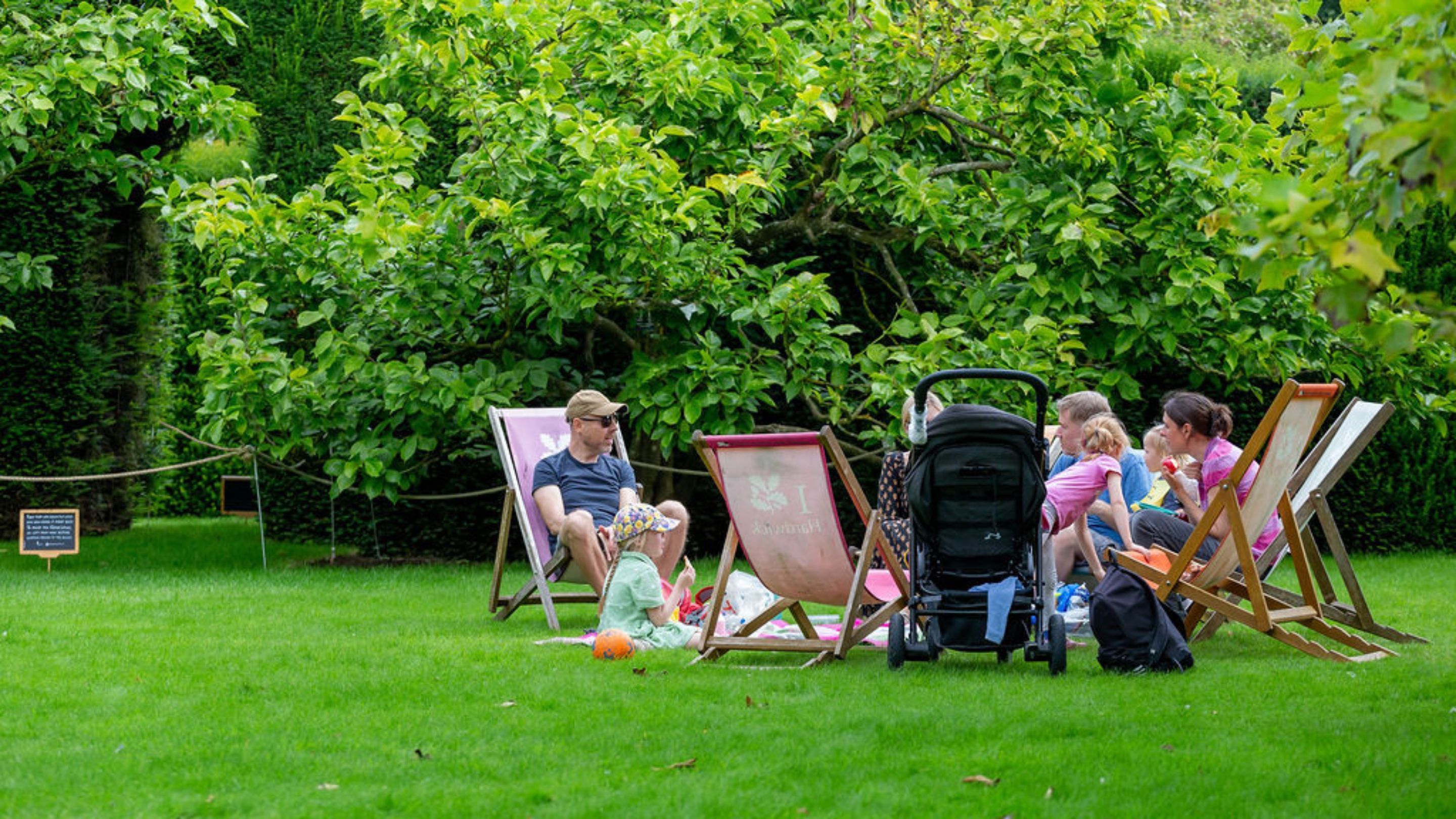A group of visitors relax on the colourful deckchairs on the South Lawn.