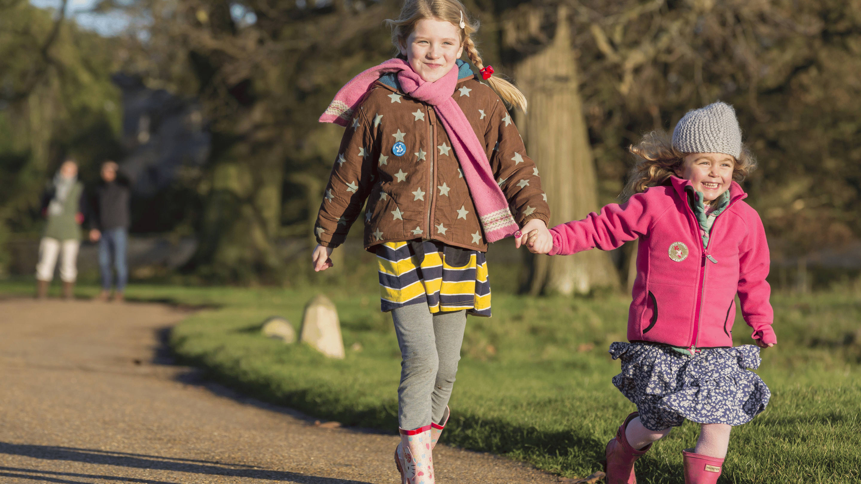Two girls excitedly running down a path