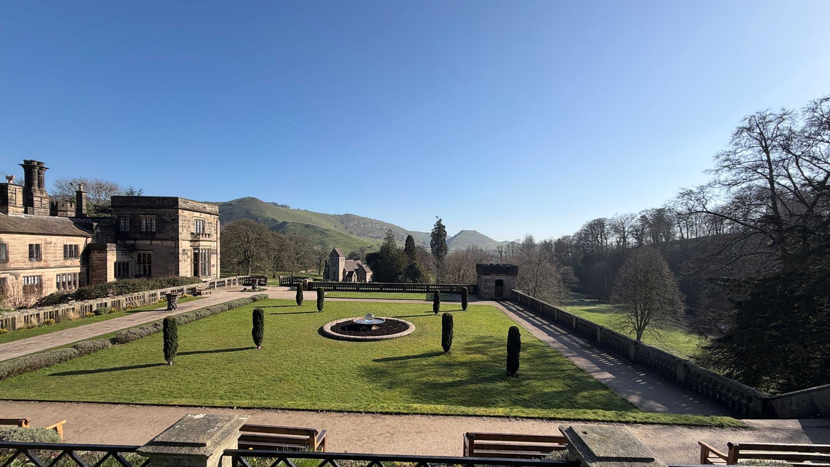 A view over Italian gardens with a flat topped cloud in the background