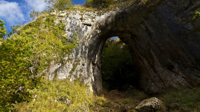 Reynards Cave on a sunny day at Sharplow Dale in Dovedale, South Peak Estate, Derbyshire.