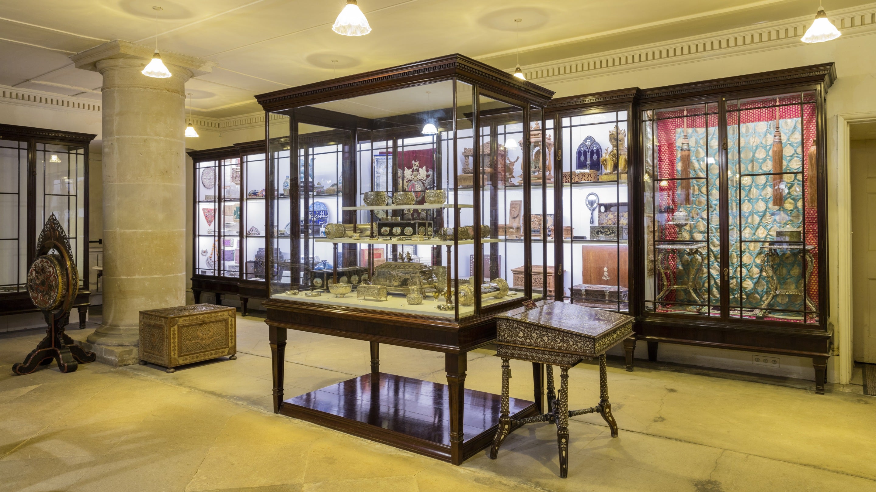 A view into the museum at Kedleston Hall with a large display cabinet in the centre