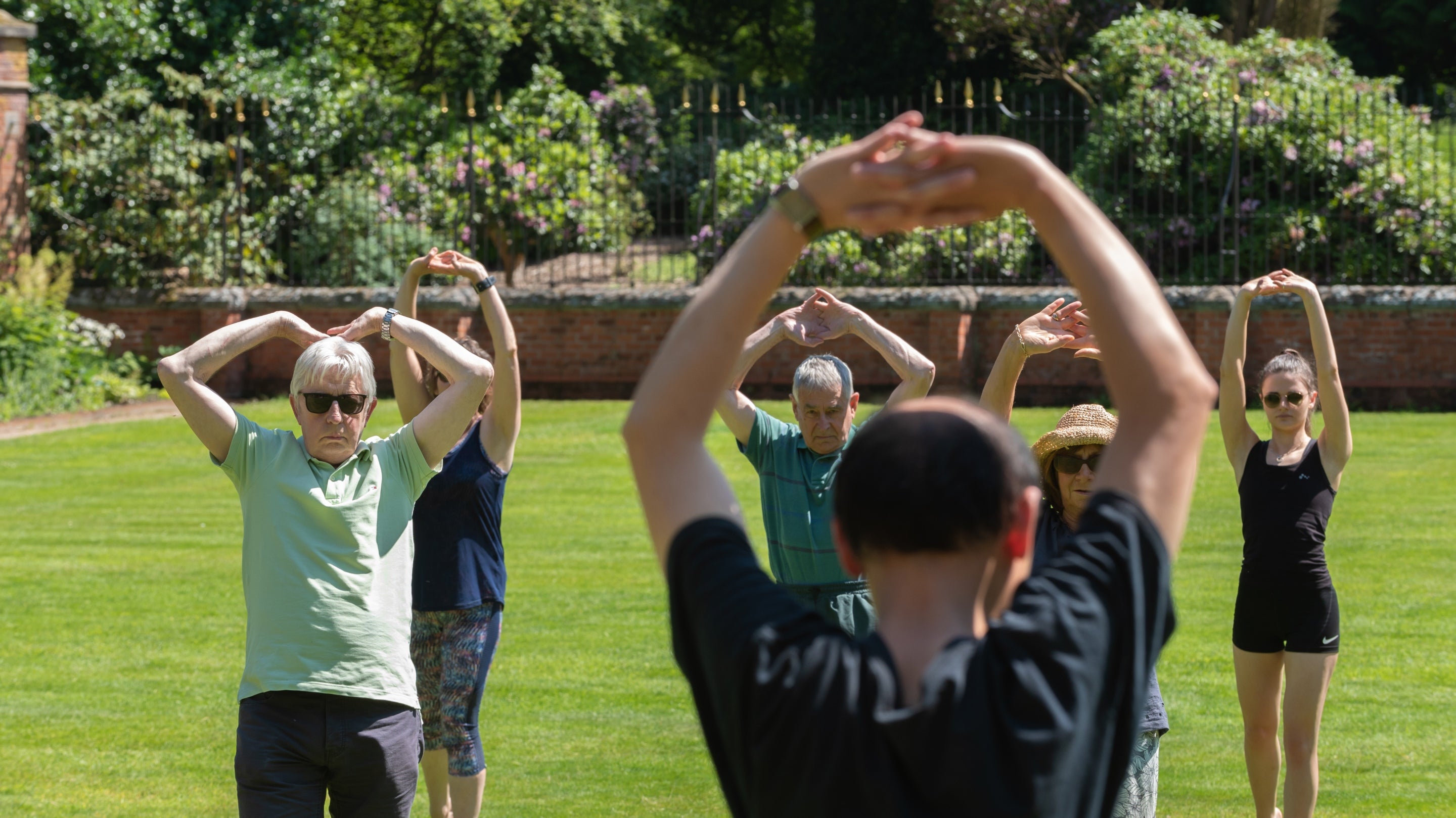Visitors try Tai Chi in a walled garden