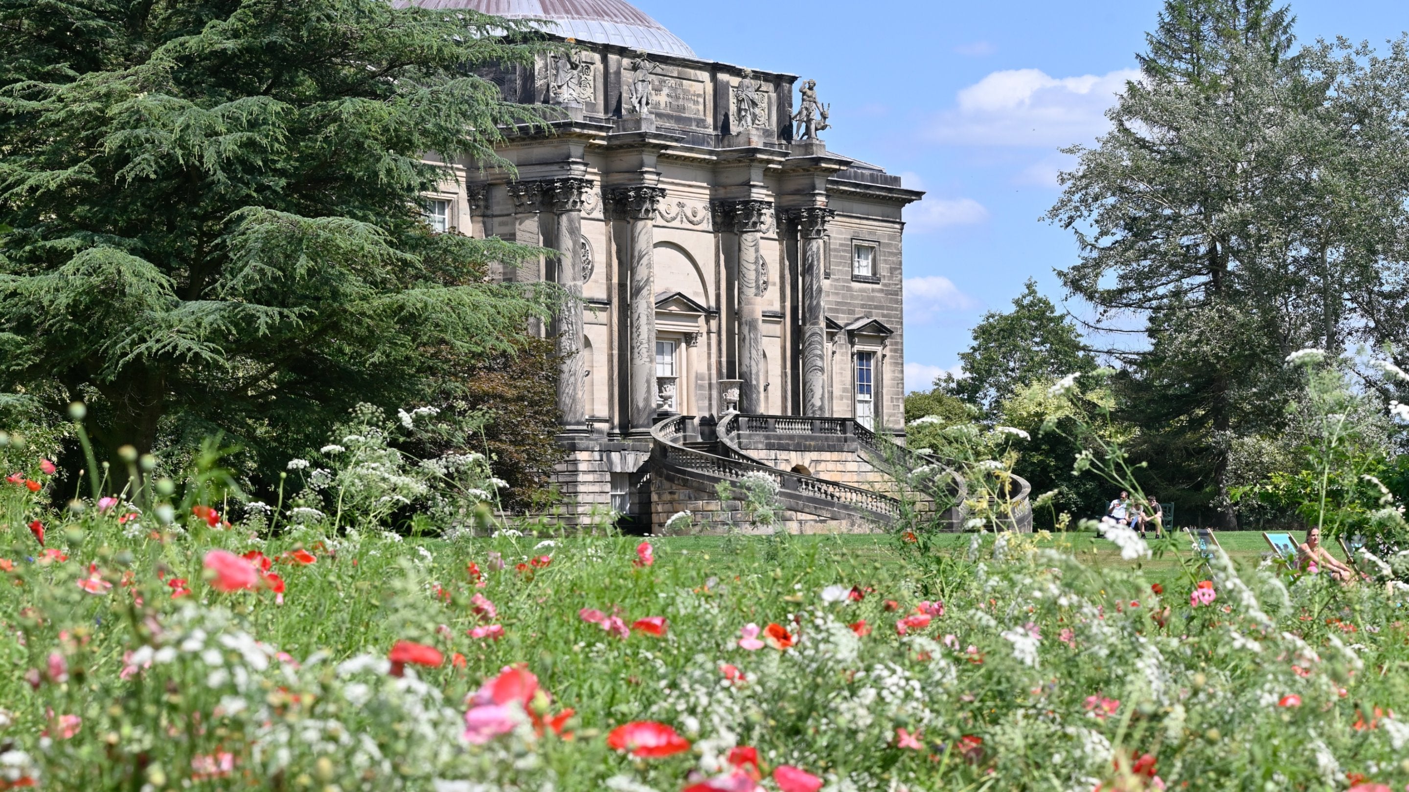 View of the house and wildflowers in the garden at Kedleston Hall, Derbyshire
