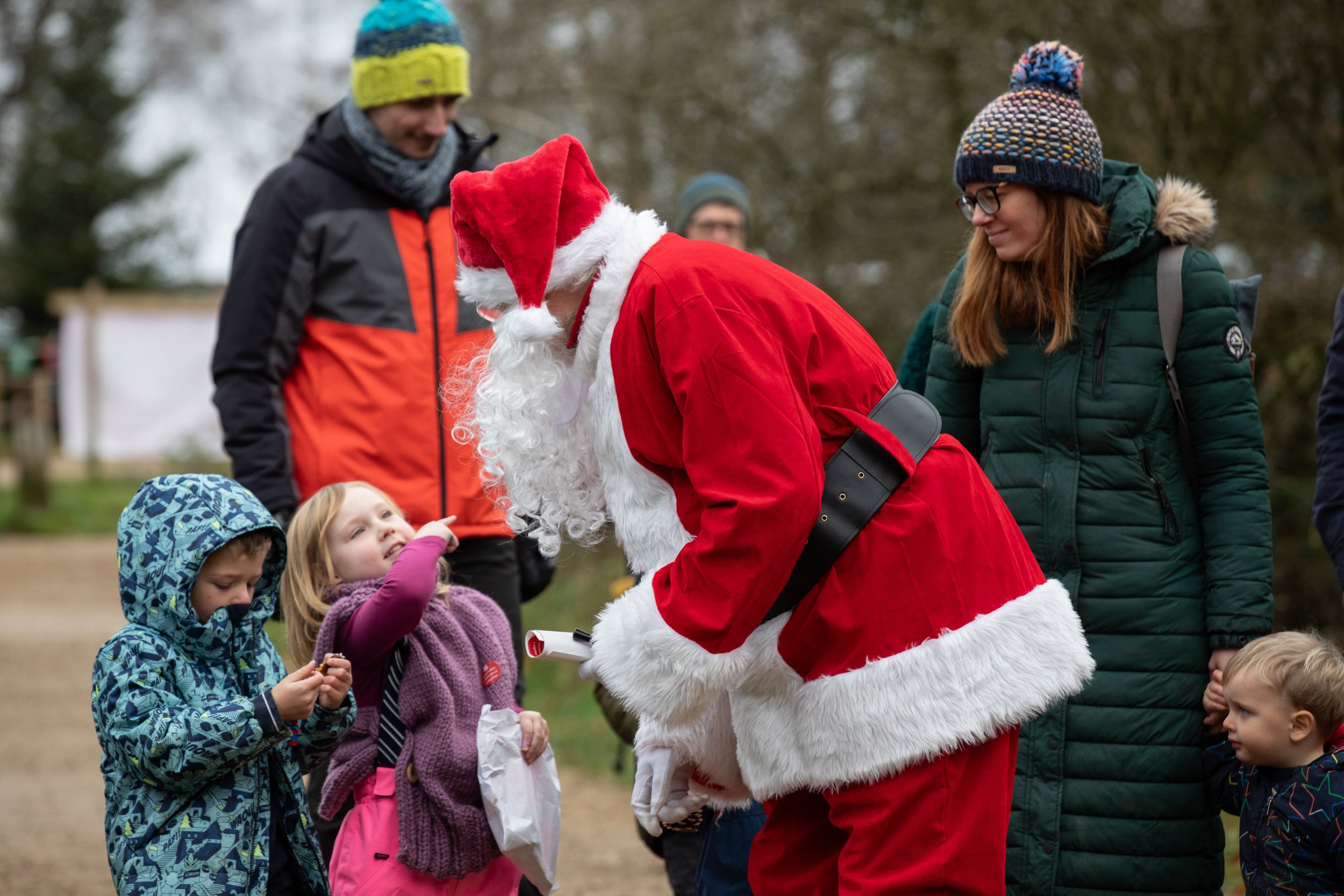 Father Christmas engaging with family at Longshaw's Christmas Tree Festival
