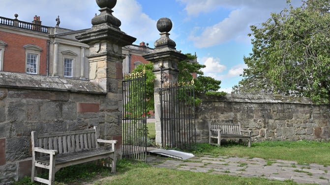 A ramp and two wooden benches in the churchyard at Staunton Harold Church, Leicestershire